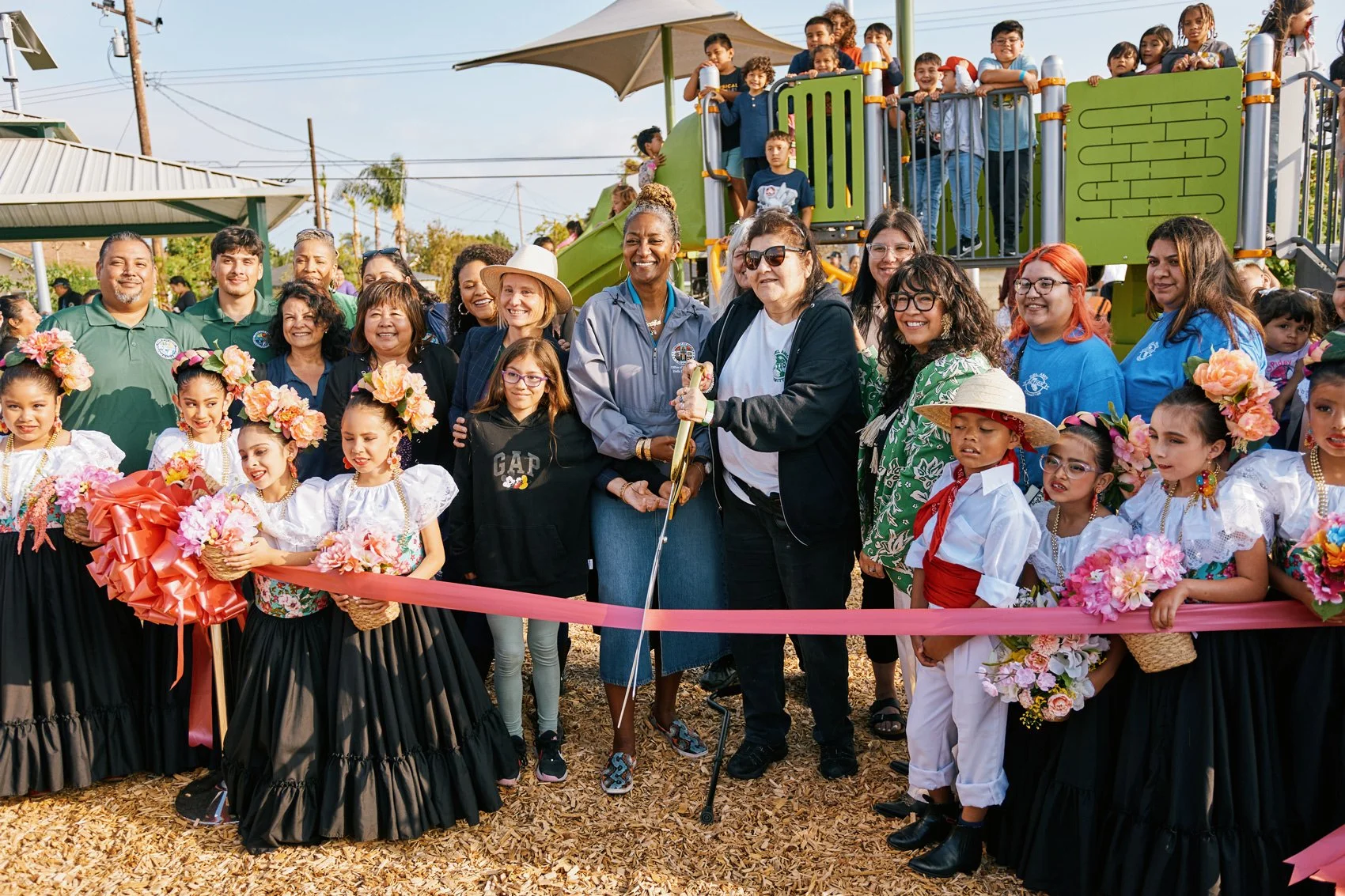 Photo of community members cutting a ribbon at the opening ceremony of Wishing Tree Park
