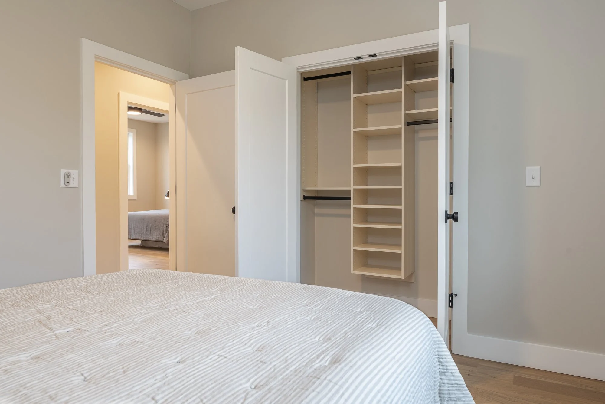 Bedroom and closet in a modern farmhouse constructed by Plumb Level Square builders in western North Carolina
