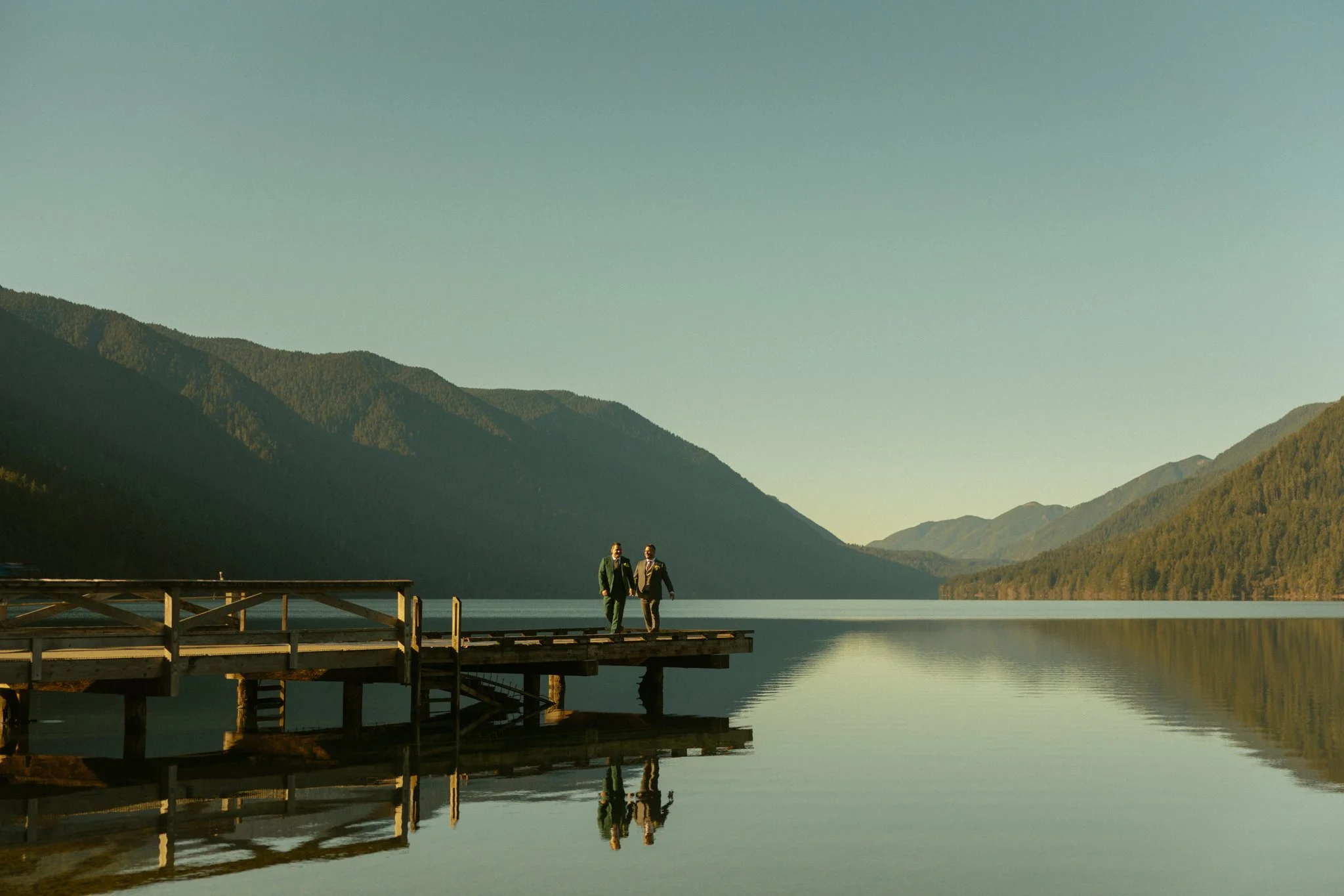 elopement couple walking along the dock at Lake Crescent in Olympic National Park