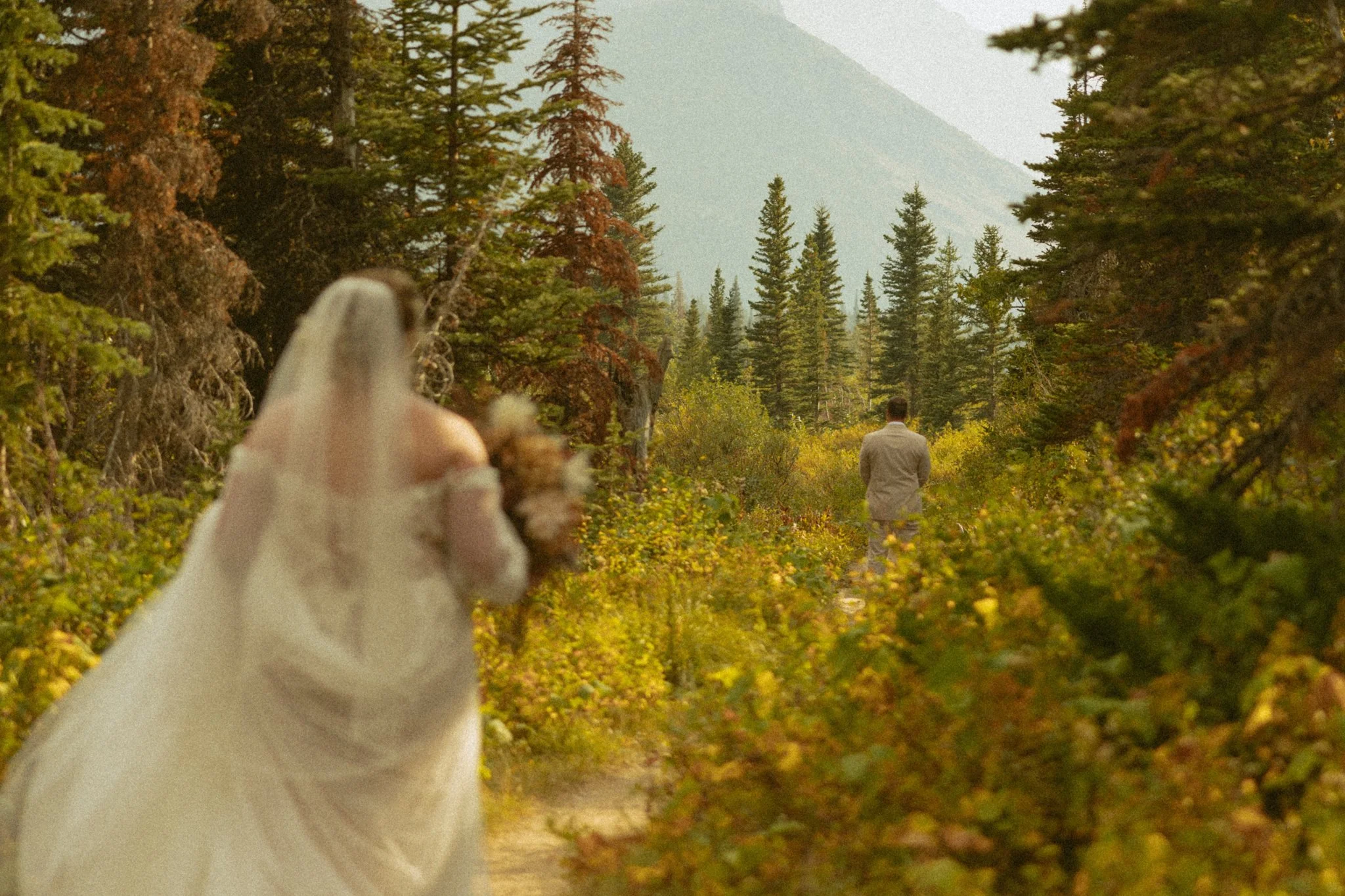 elopement couple sharing their first look on a hiking trail in Montana's Glacier National Park