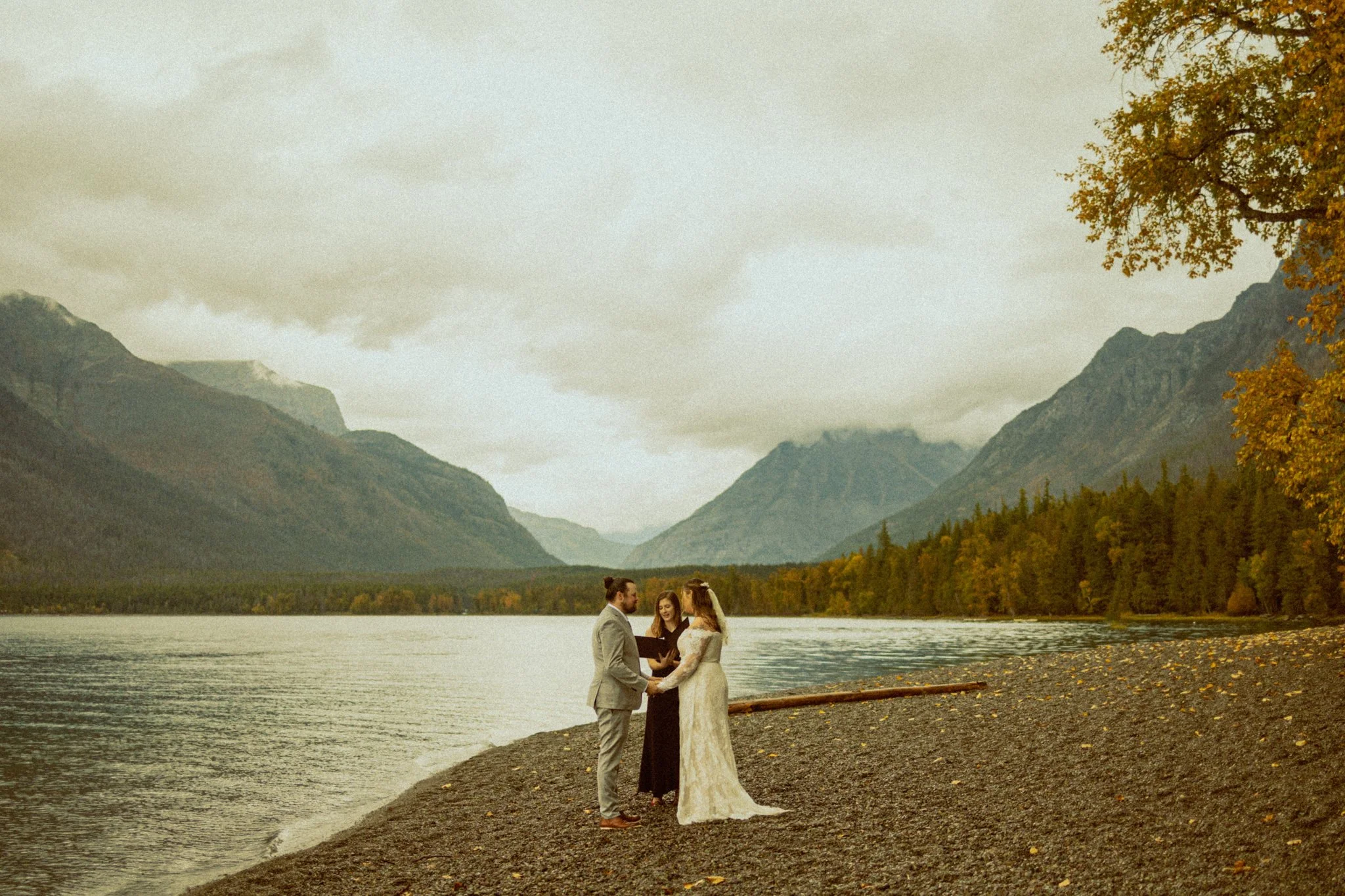 couple having their wedding ceremony along Lake McDonald in Montana's Glacier National Park