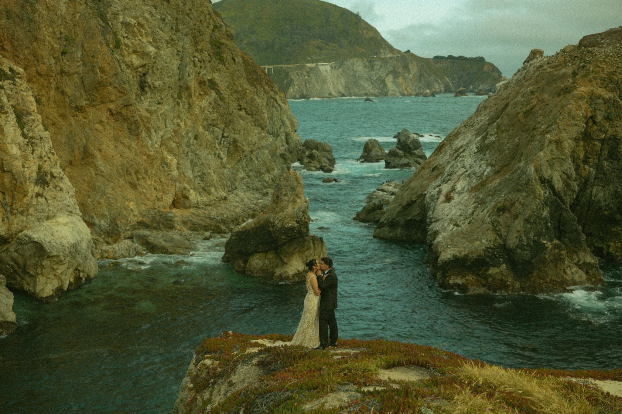 elopement couple kissing on oceanside cliffside in Big Sur