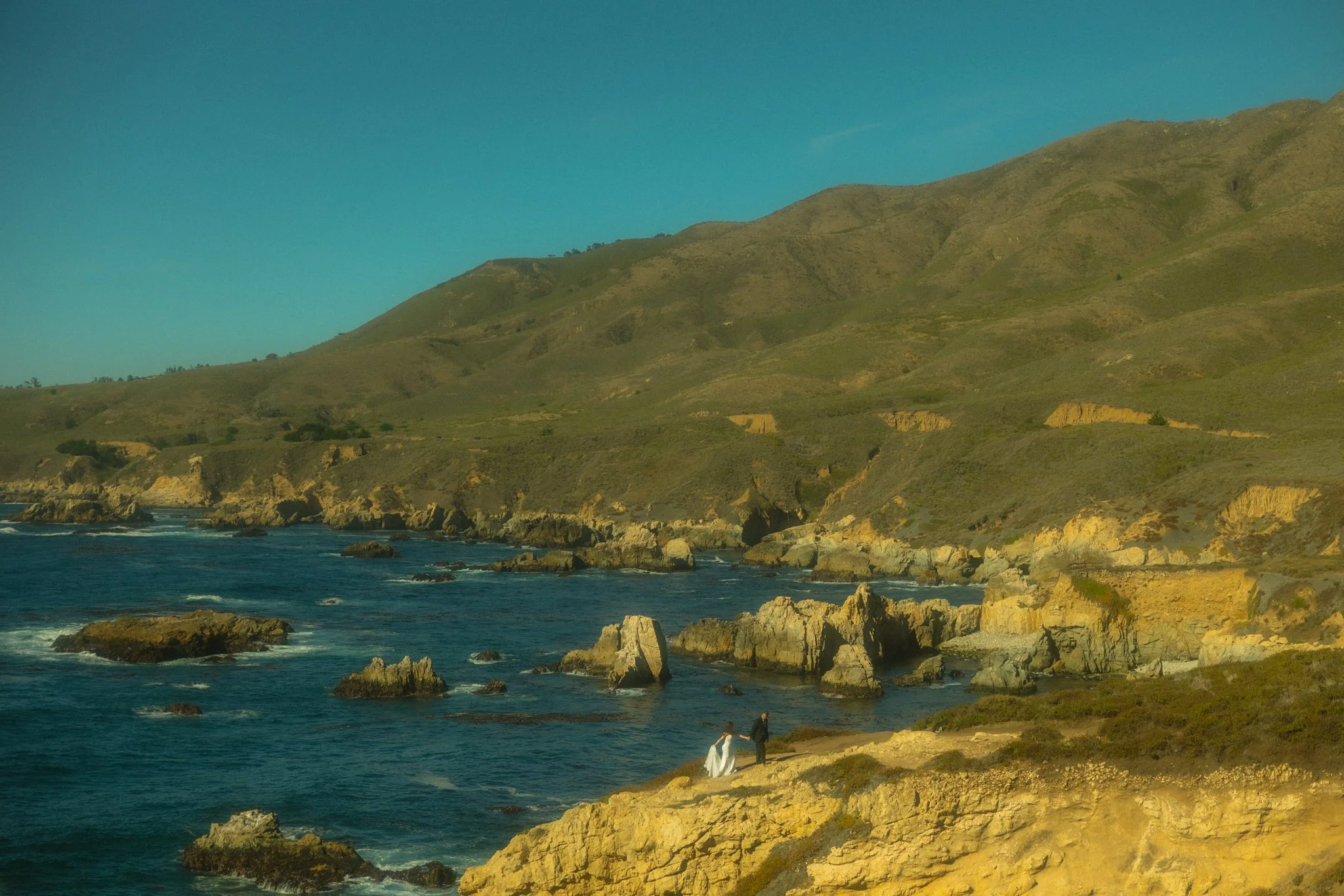 an elopement couple on a rugged coastal cliff edge in Big Sur