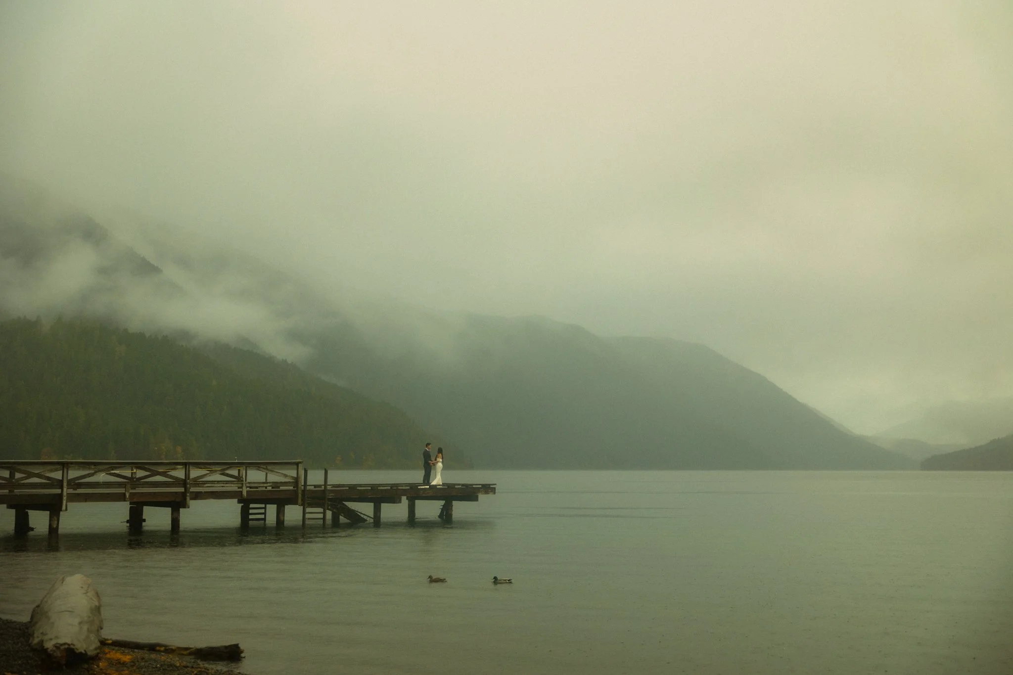 elopement couple on the Lake Crescent Dock on a moody October day in Olympic National Park