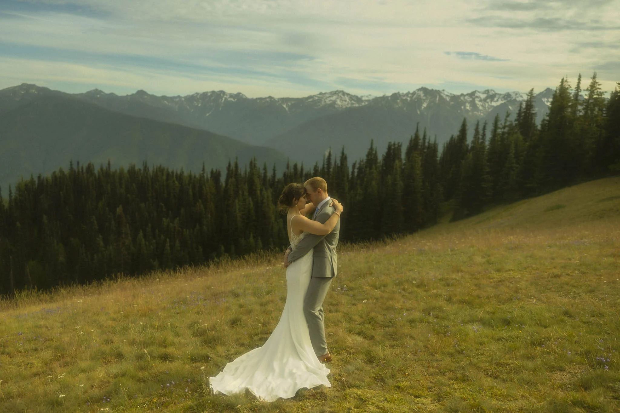 an elopement couple embracing in a wildflower meadow at Hurricane Ridge in Olympic National Park