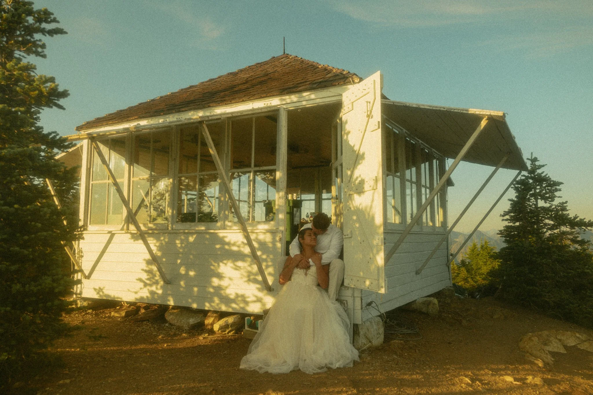 elopement couple cuddling in mountaintop fire lookout in Washington state