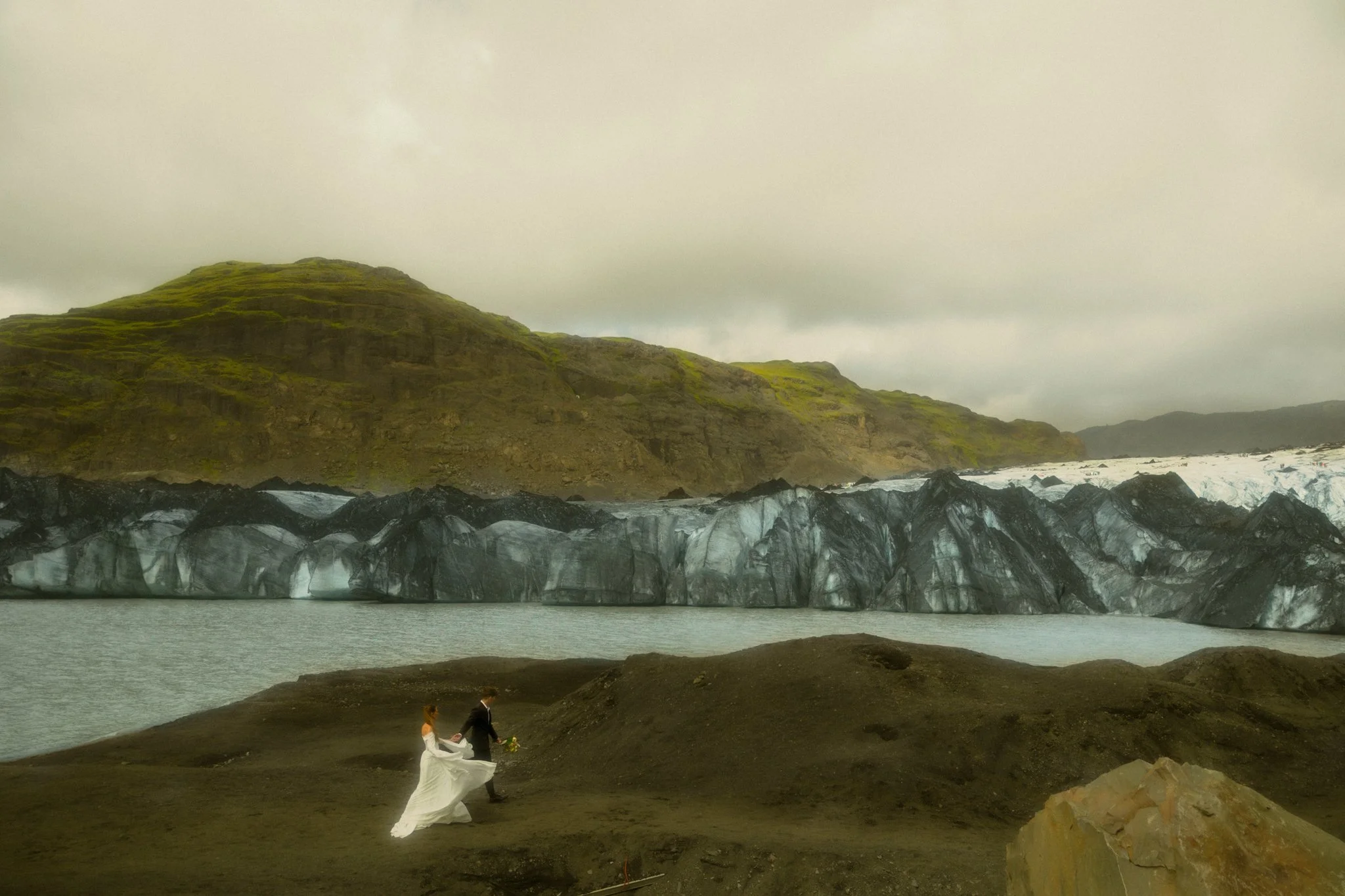 an elopement couple walking near a glacier lagoon in Iceland