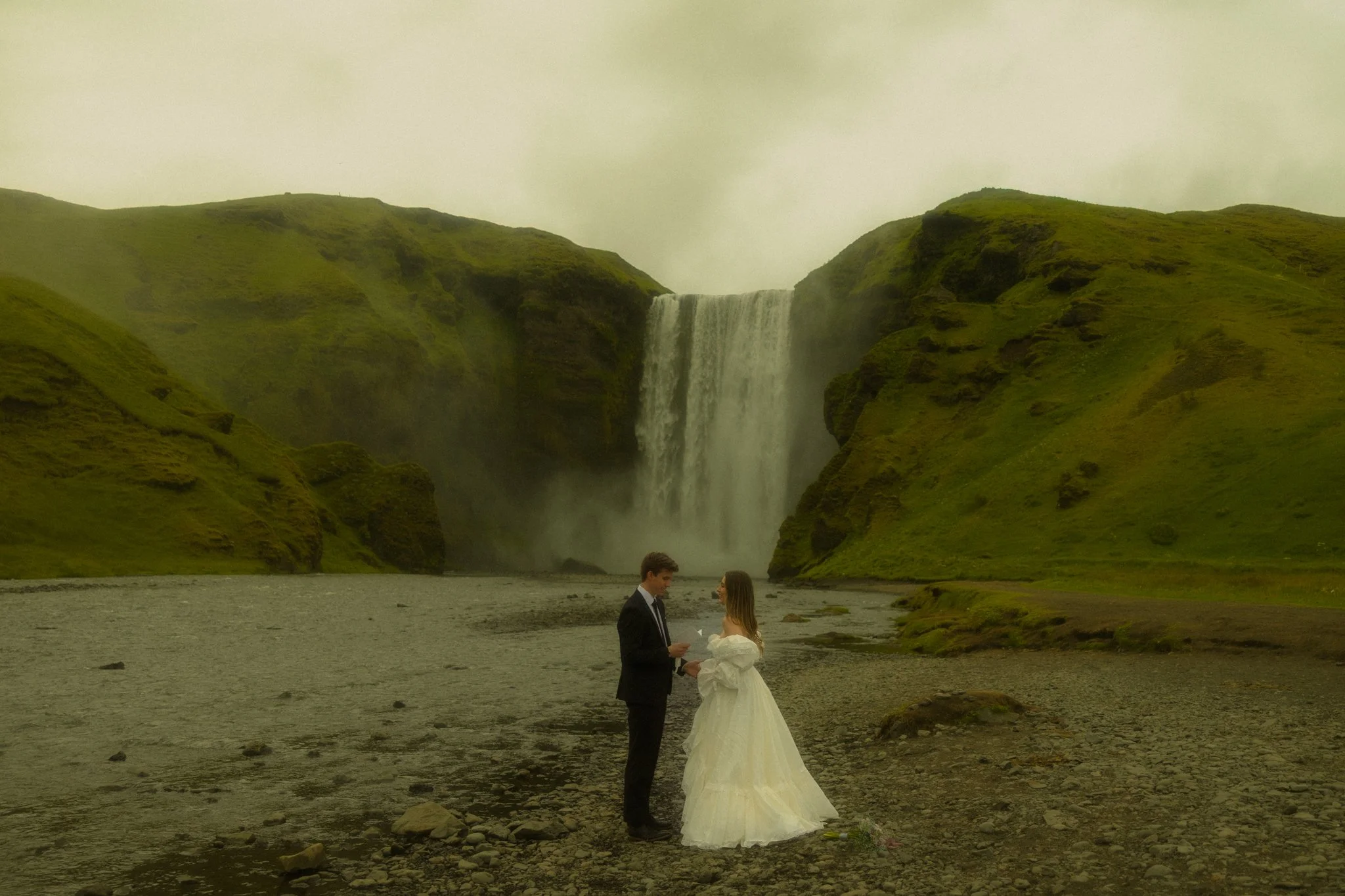 a couple sharing their vows at Skogafoss in Iceland