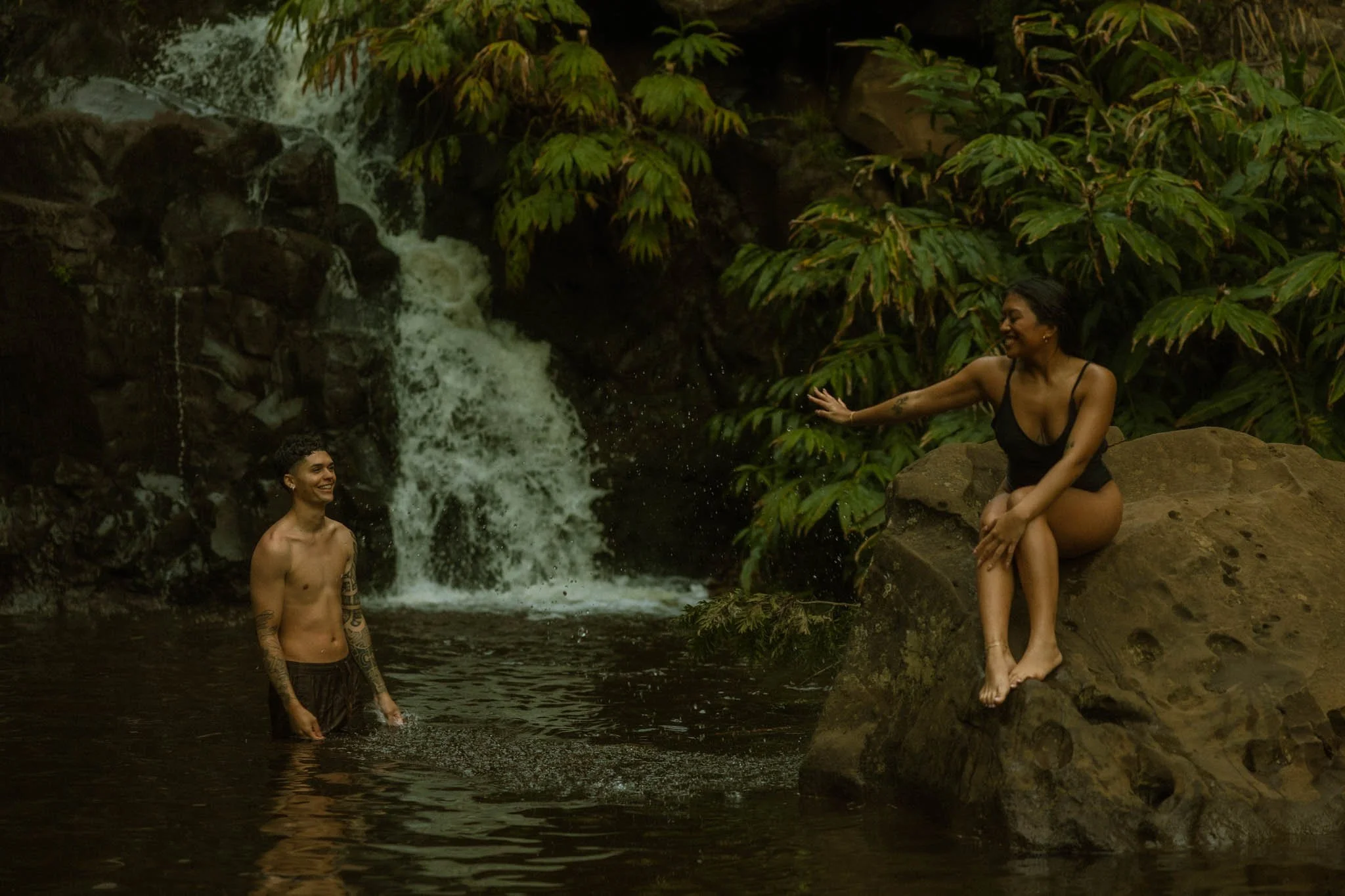 couple swimming in waterfall after their elopement on Kauai, Hawaii