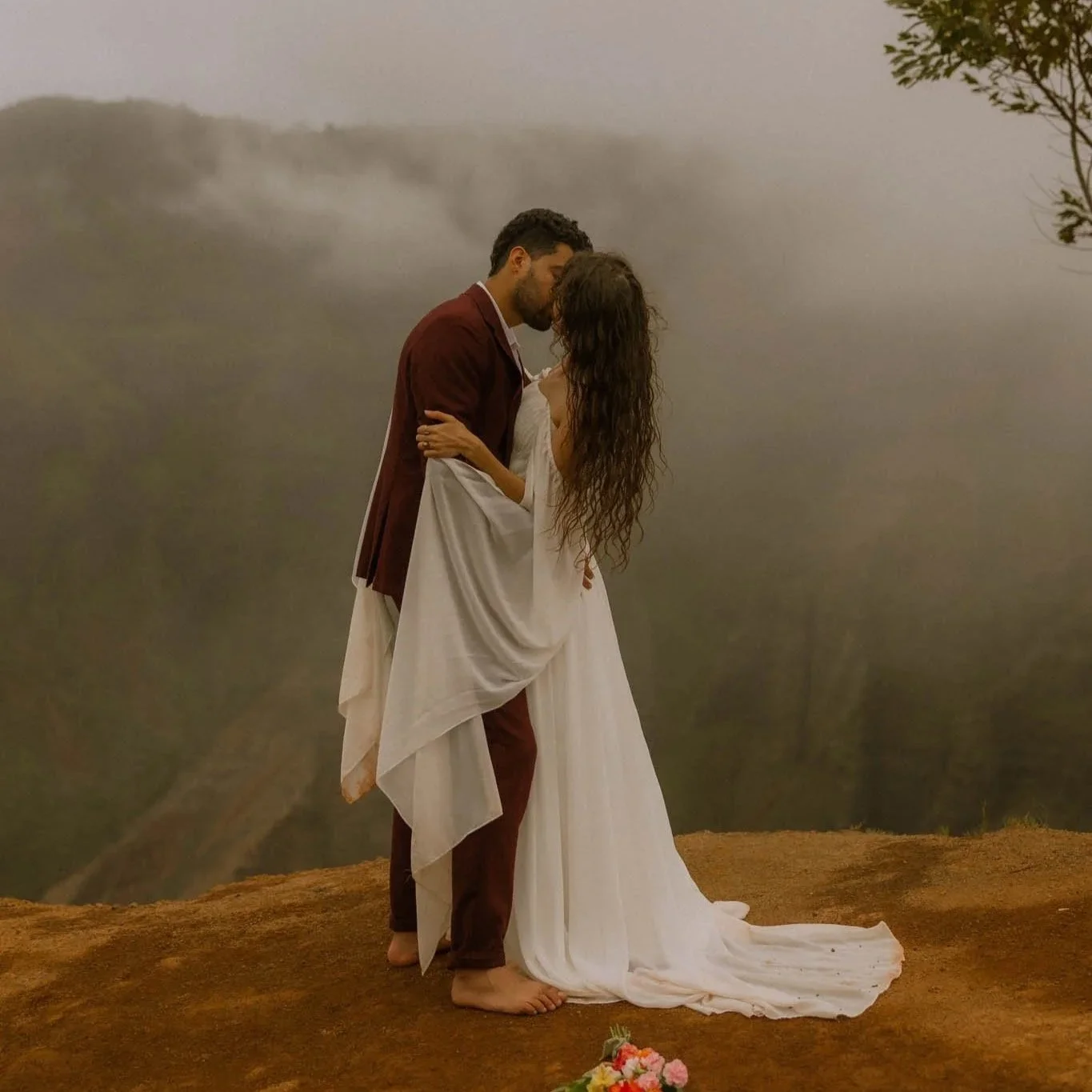 an elopement couple sharing a kiss along the Waimea Canyon in Kauai