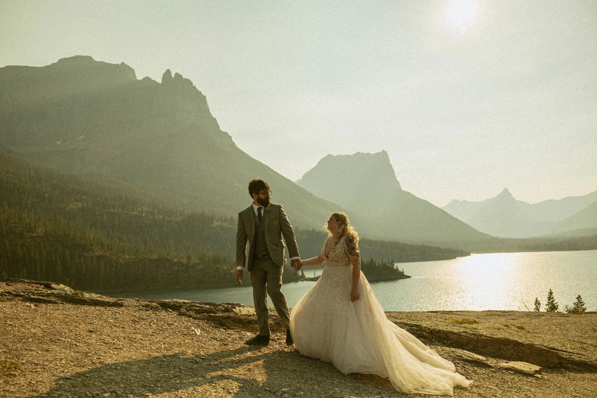 couple getting married along lake cliff edge in Glacier National Park