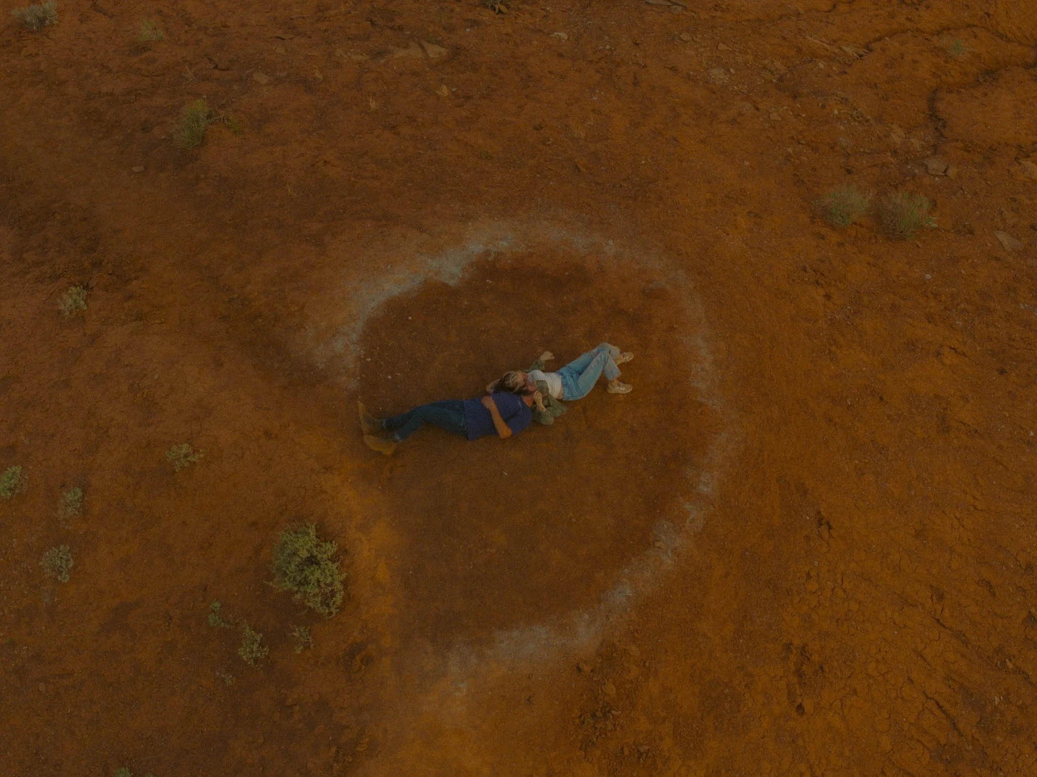 a couple laying on the red dirt desert in Moab, Utah