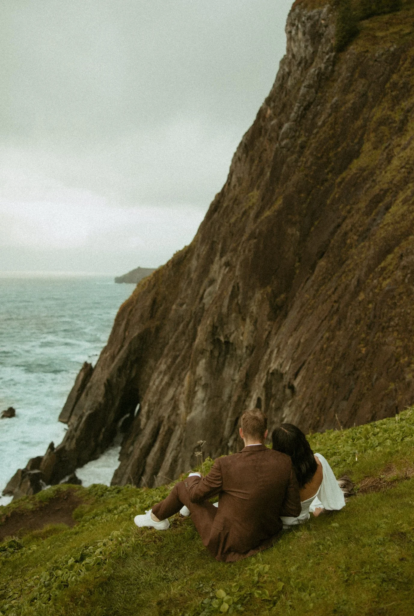 elopement couple looking at ocean on Oregon coast