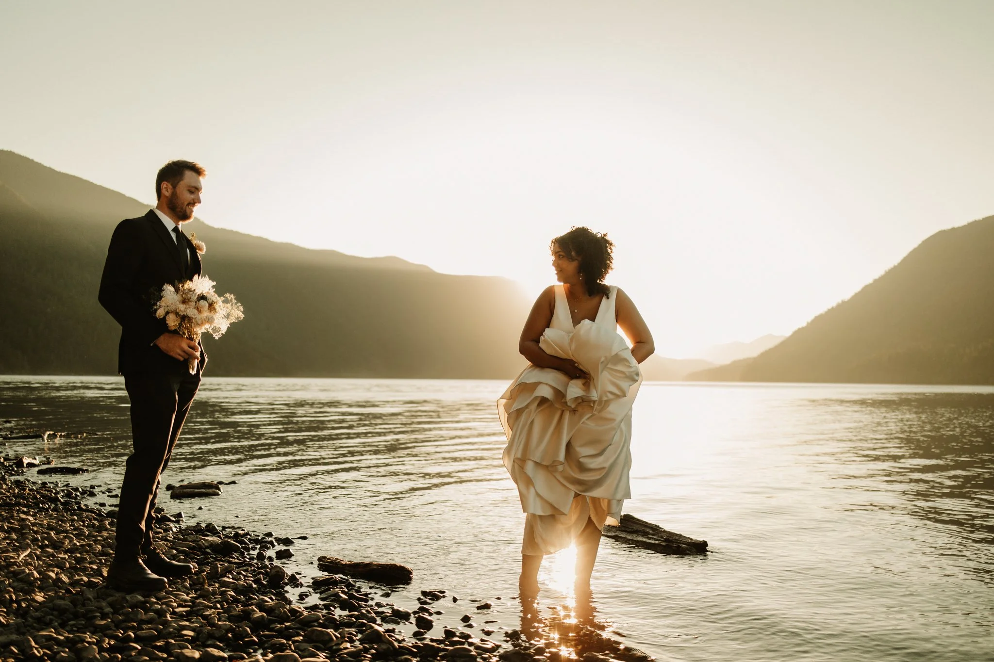 elopement couple dipping their toes into Lake Crescent in Olympic National Park