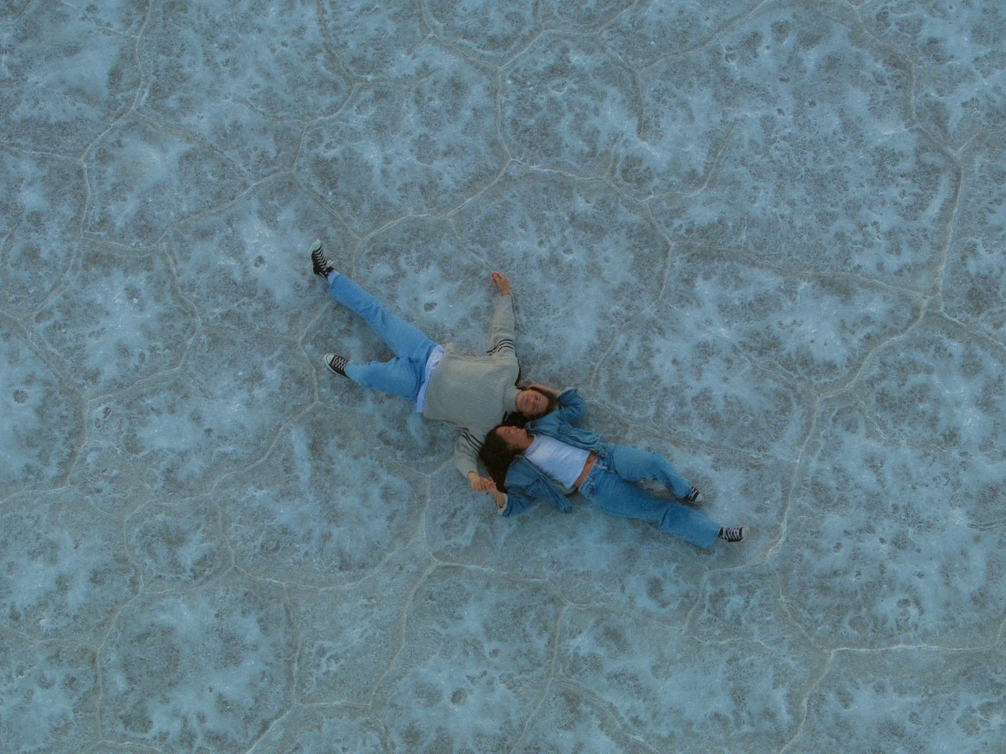A couple laying down on the Salt Flats in Utah