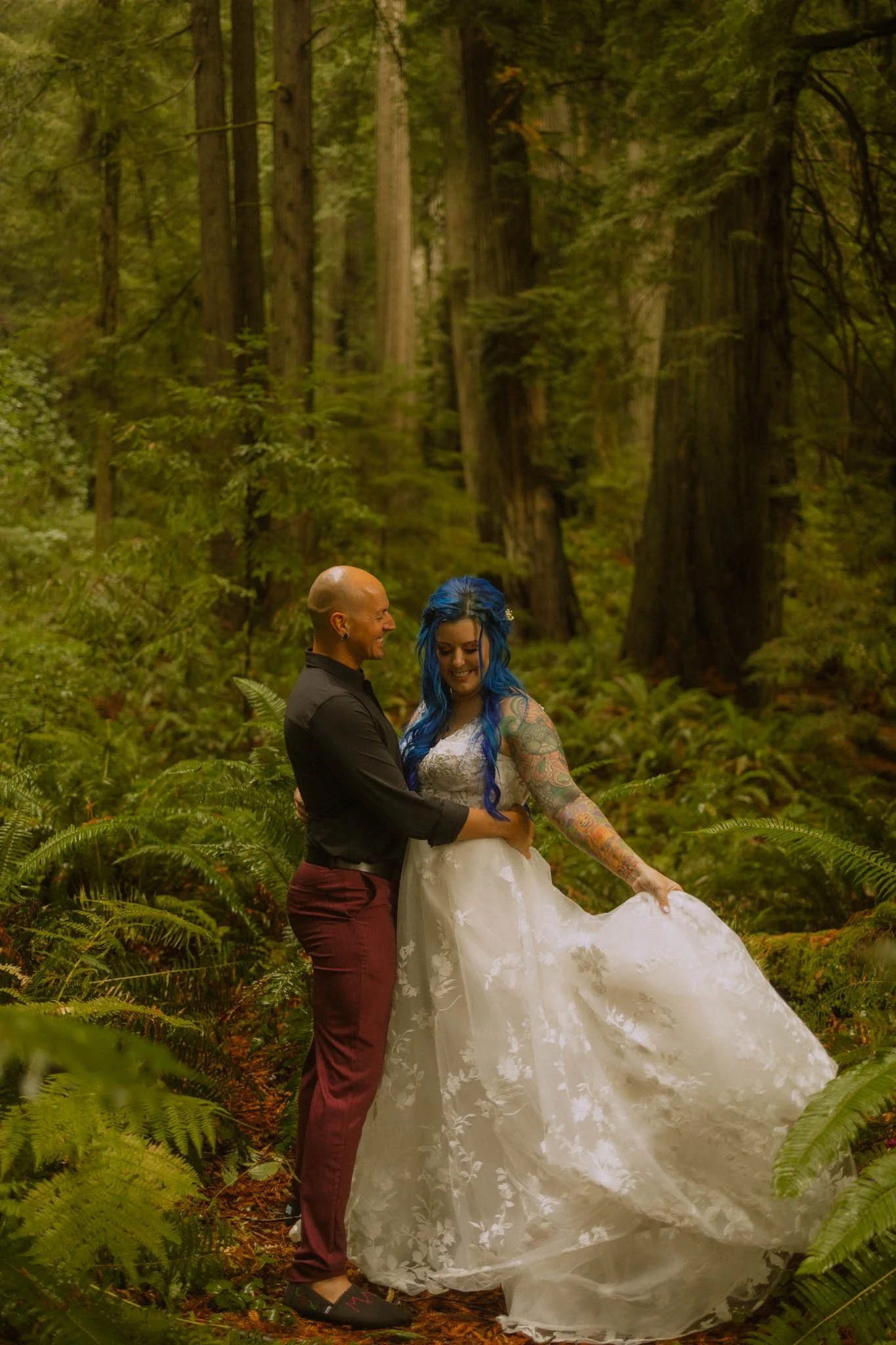 couple among wet ferns in lush forest on elopement day