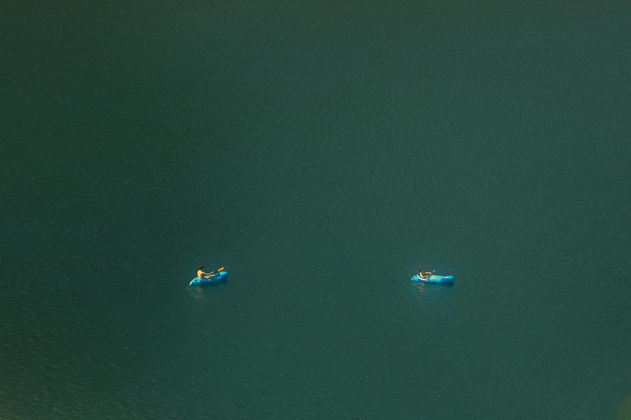 couple pack rafting on an alpine lake on their elopement day