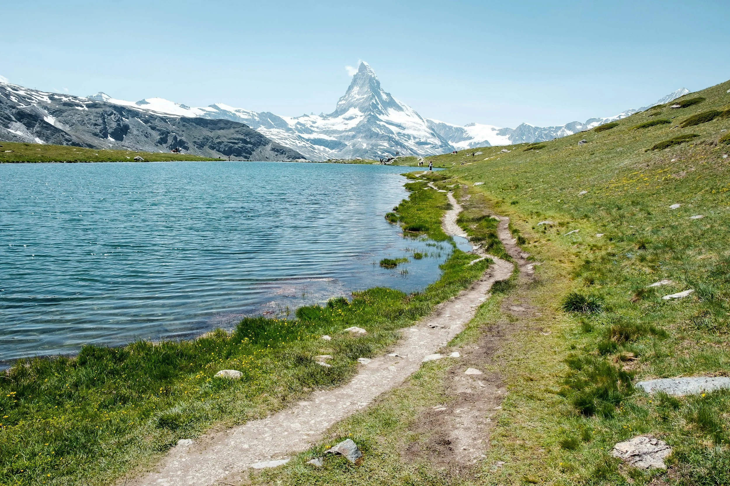 a landscape photo on a trail with an alpine lake with the Matterhorn in the background