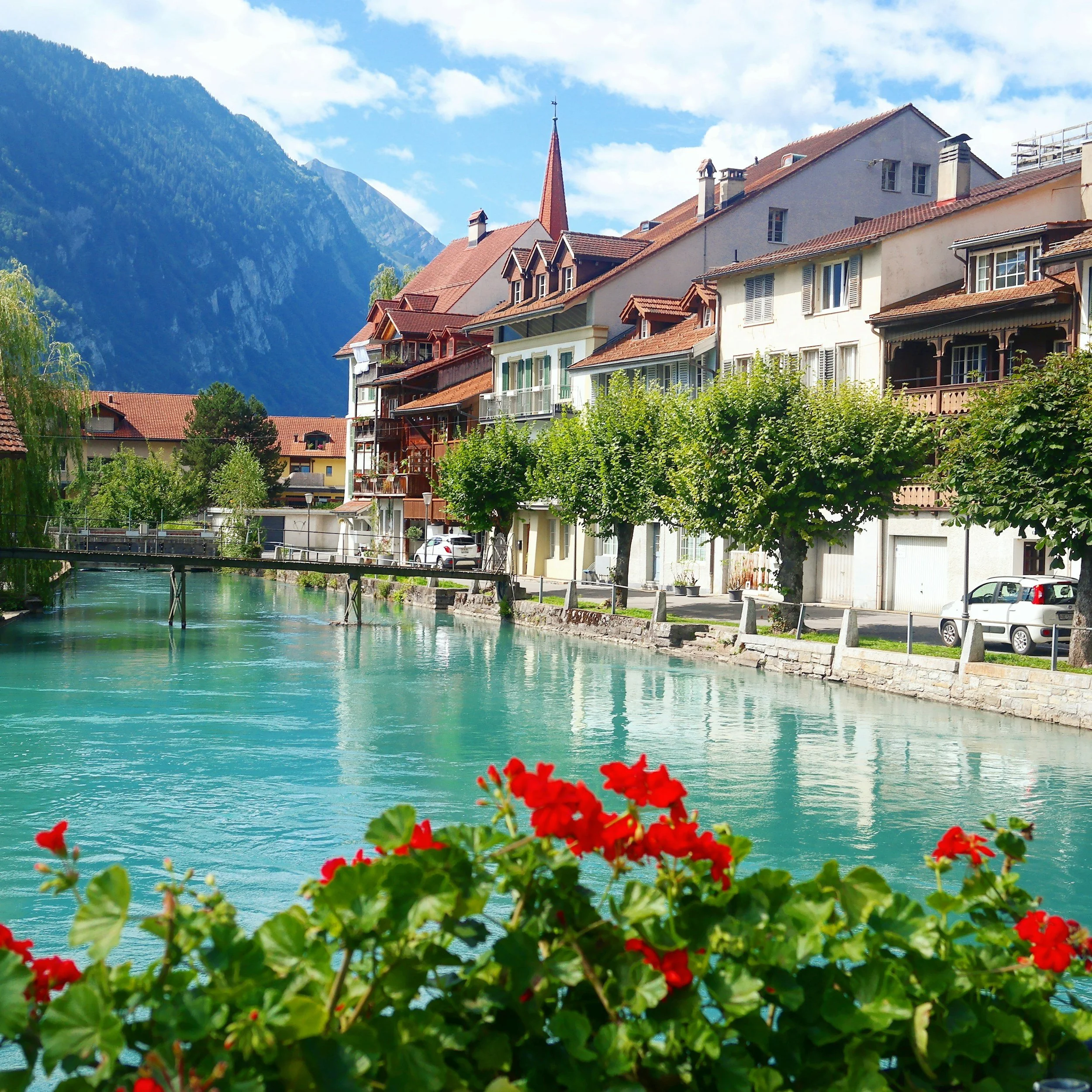a view of a mountain town and canal in Interlaken, Switzerland