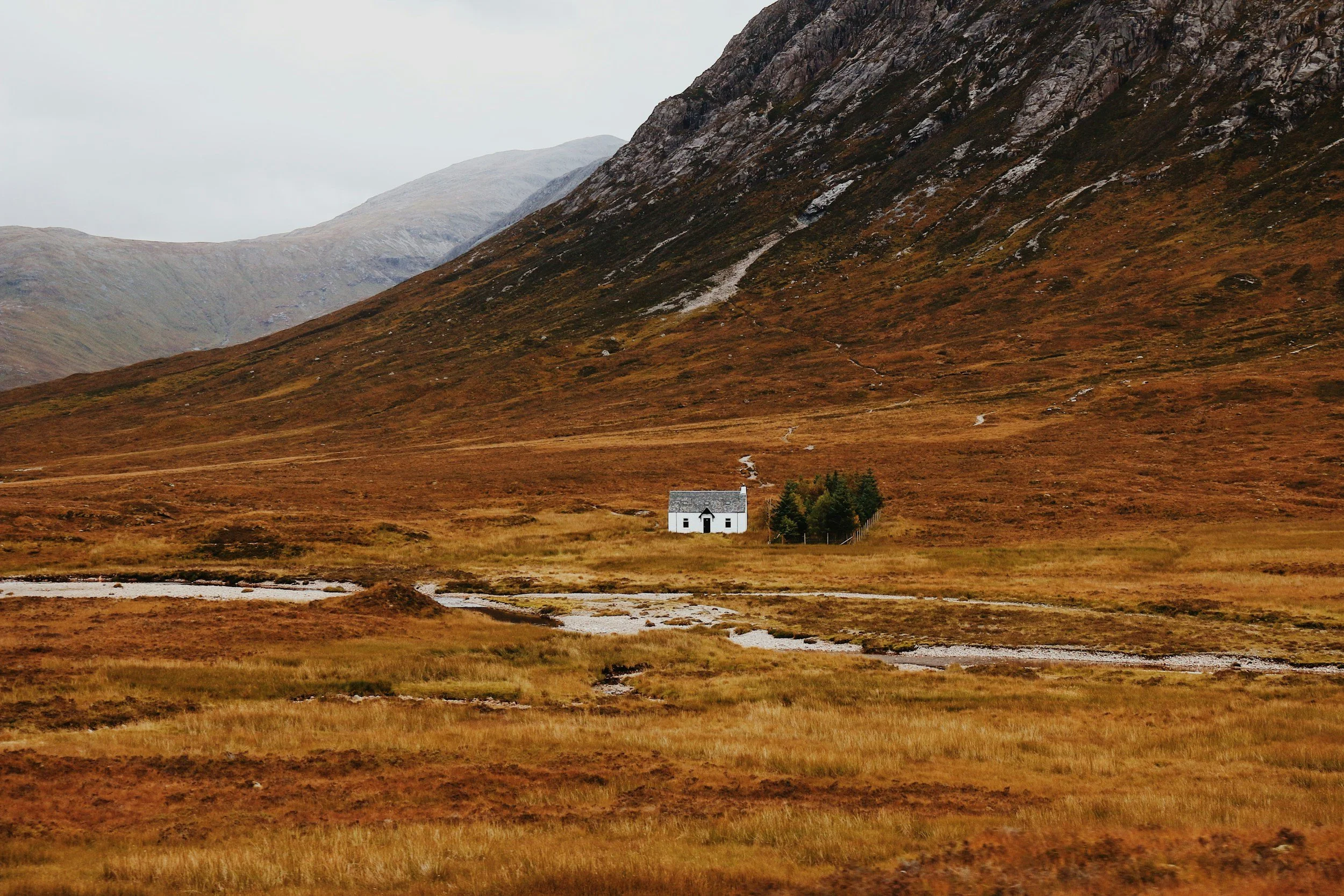 a remote little cottage in the middle of mountains in the Scottish Highlands