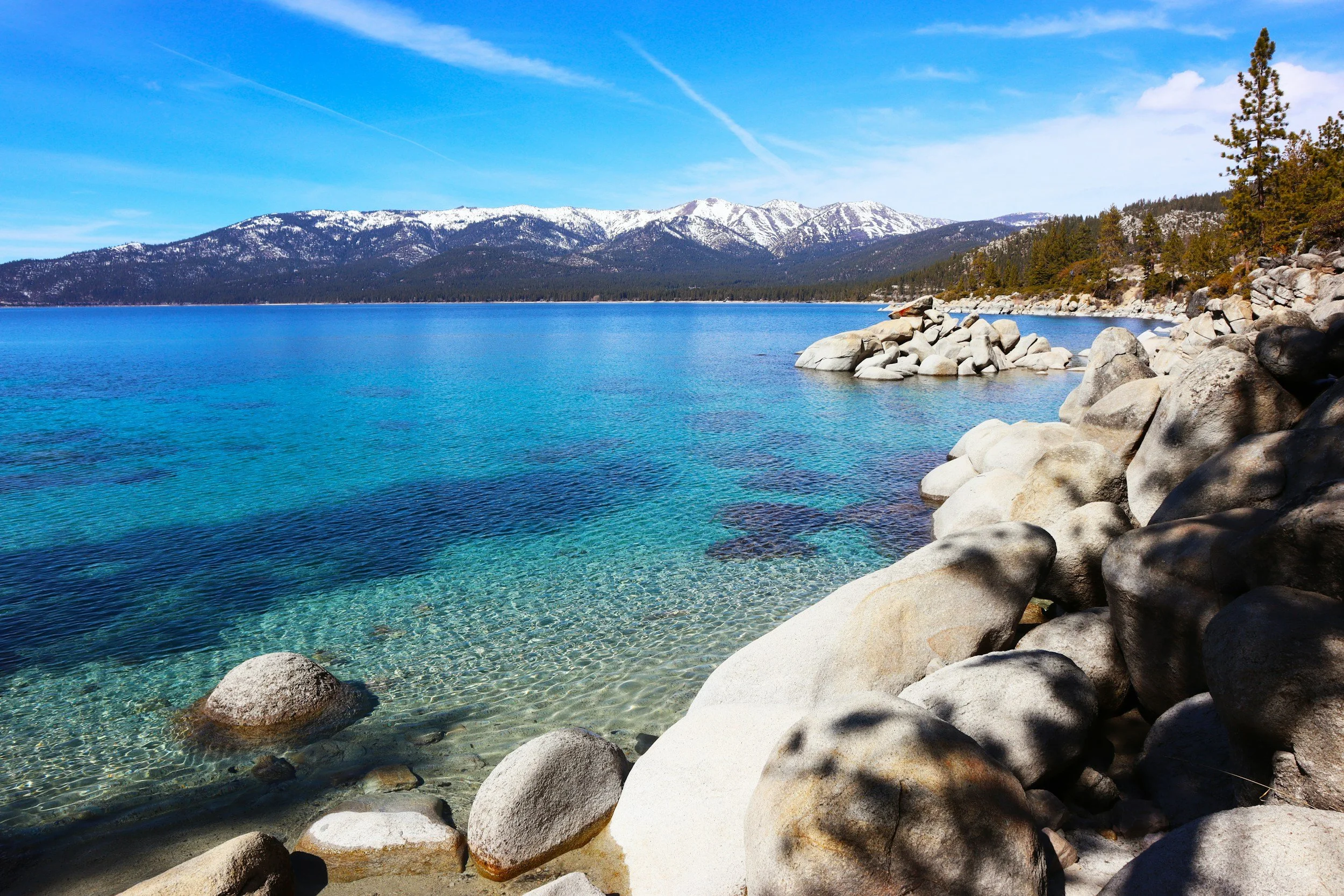 a landscape view of Lake Tahoe and the mountains from the shoreline of the lake