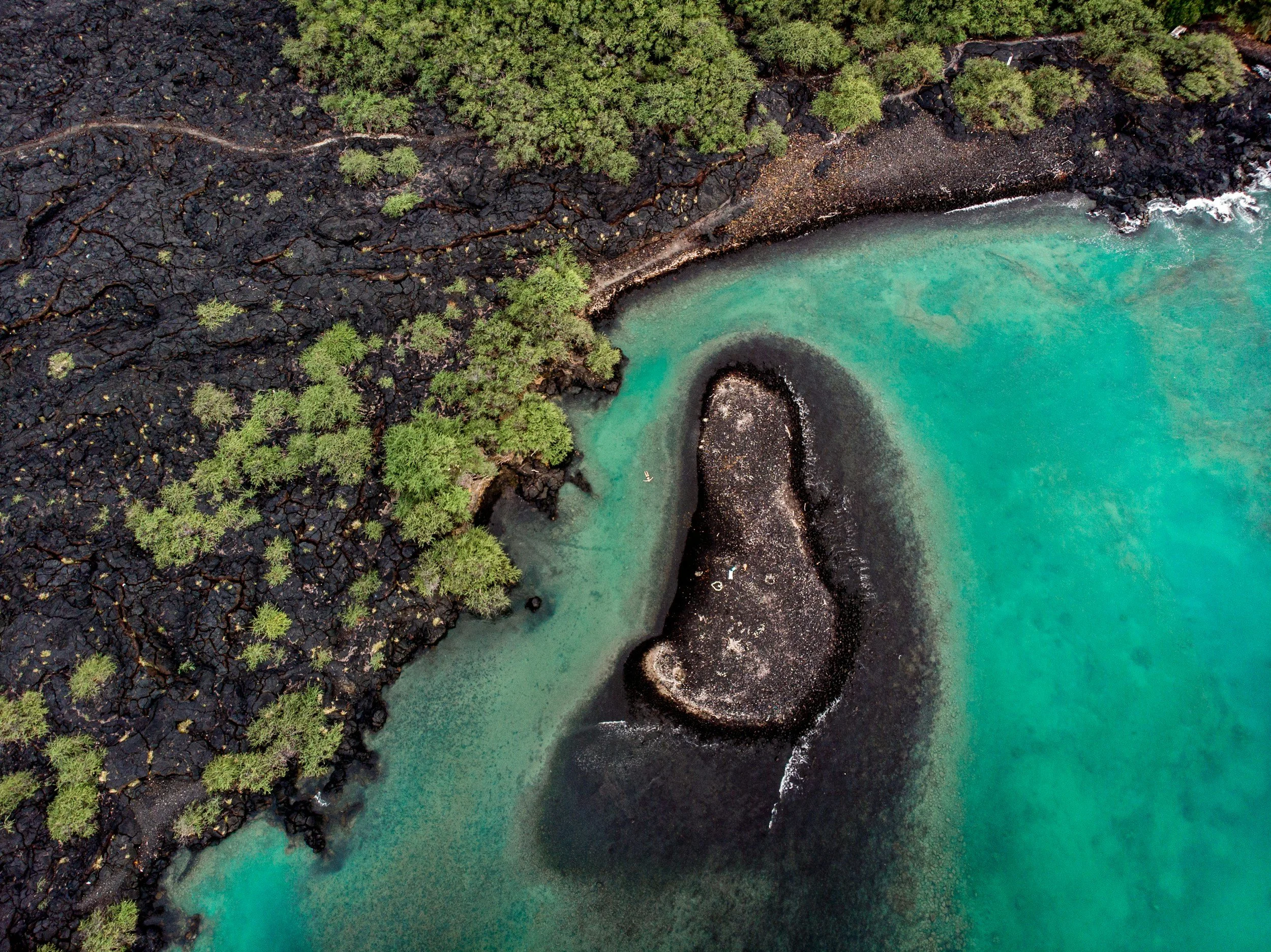an aerial photo of the black lava rock coast on the Big Island of Hawaii