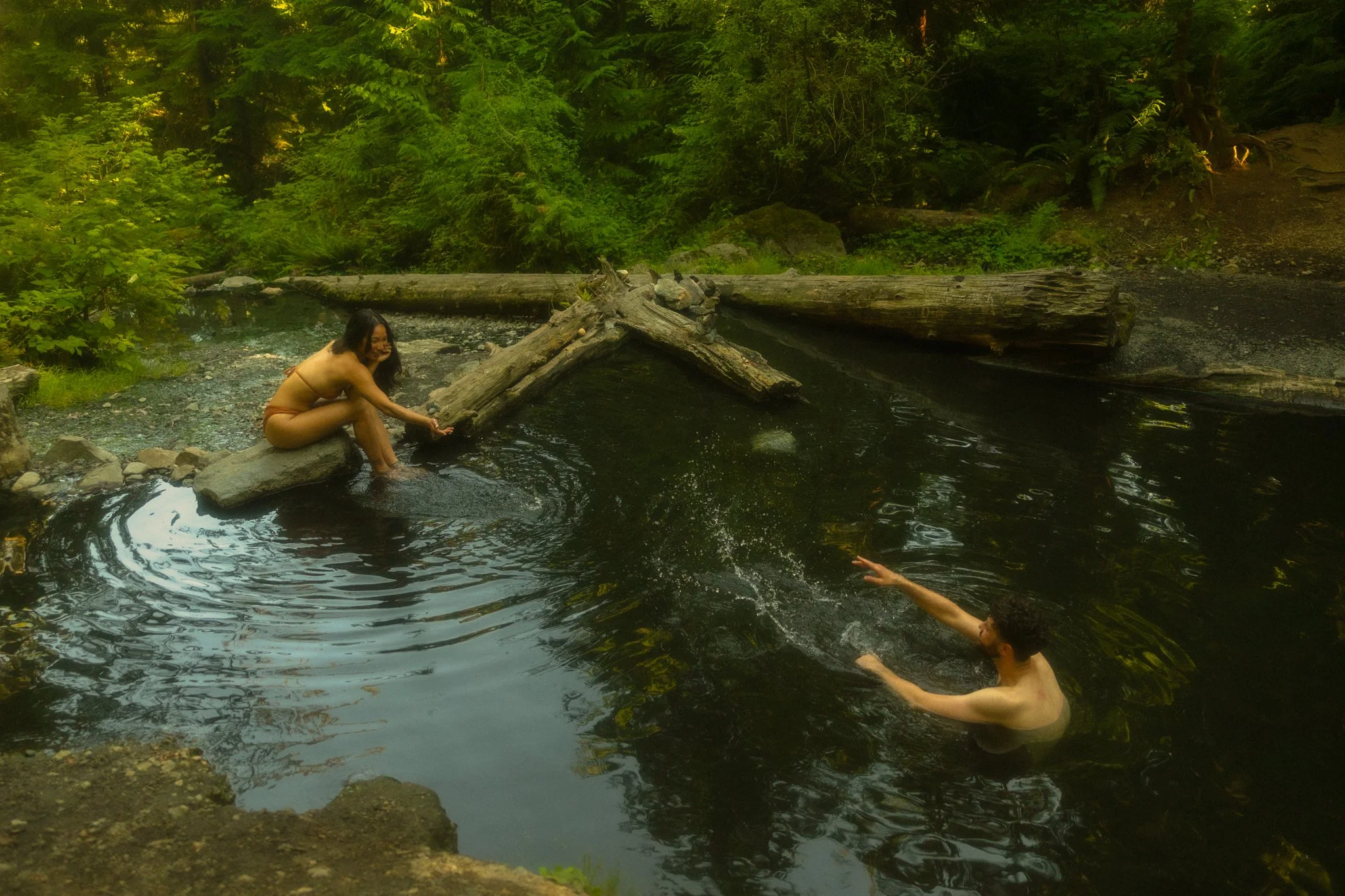 a couple relaxing in a hot spring at the end of their elopement day in the North Cascades