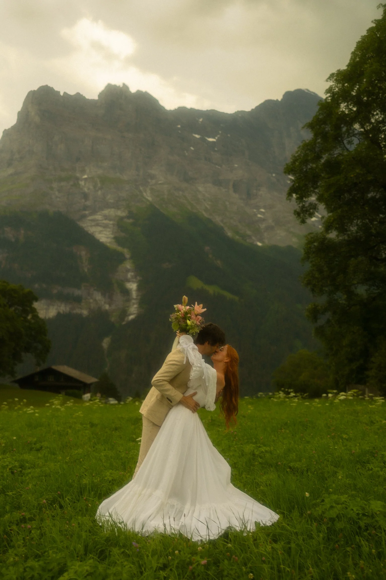 a couple eloping in a meadow within the Swiss Alps