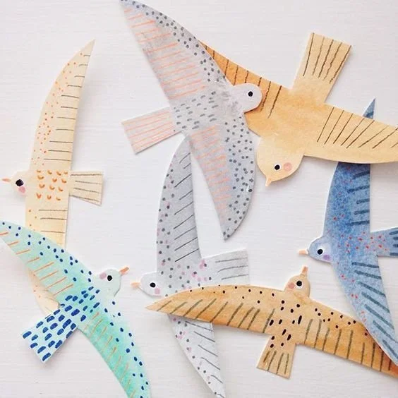 Colorful paper cutouts of various birds with detailed patterns and designs.