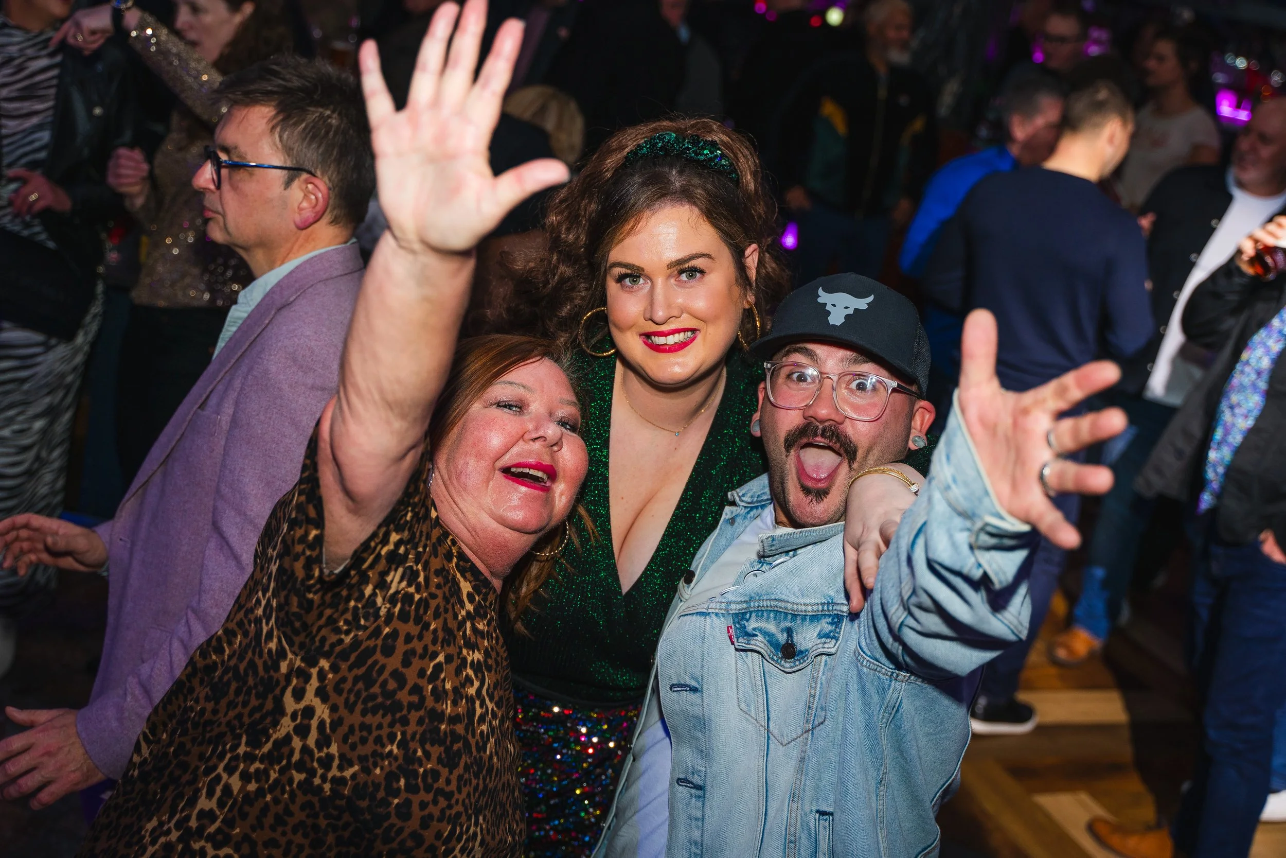 People dancing and celebrating at a party or social gathering, smiling and enjoying themselves.