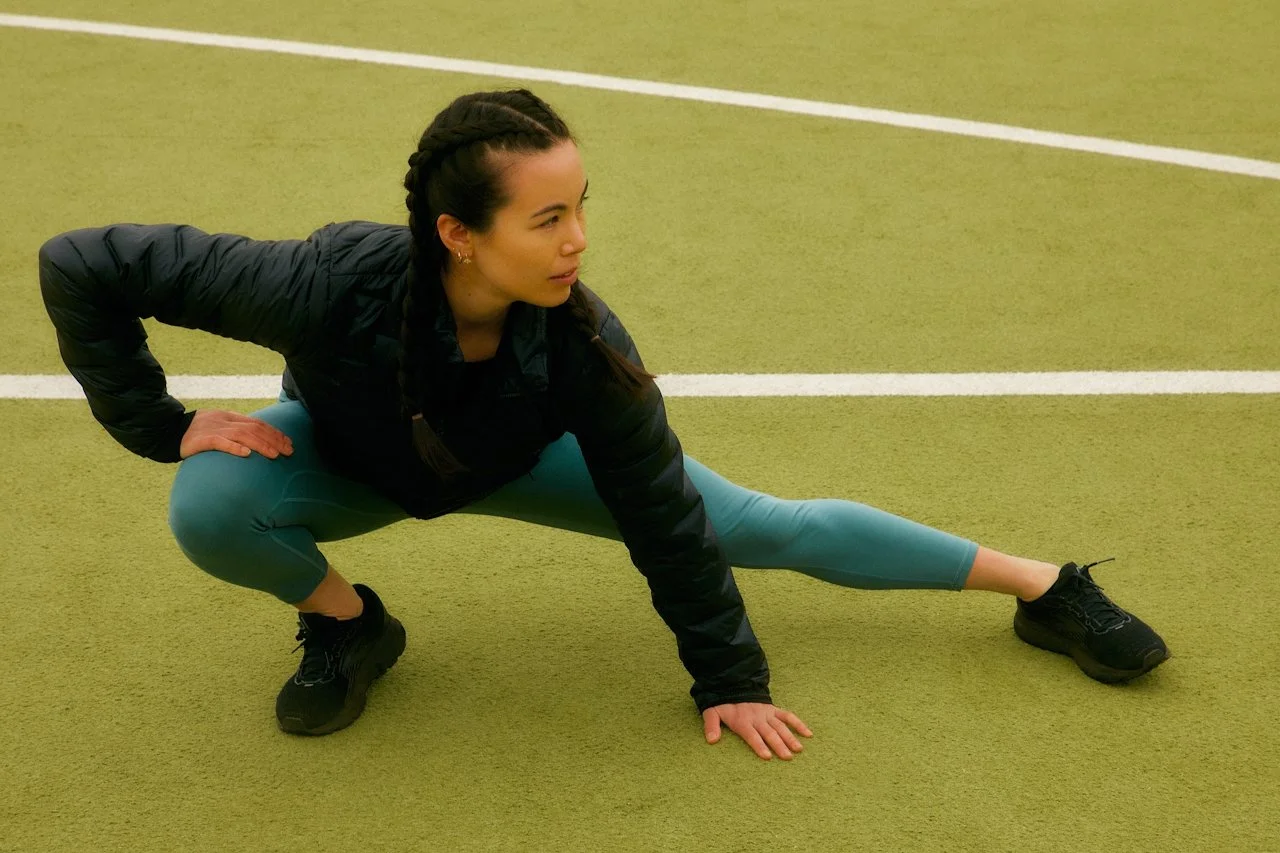 young female athlete stretching during training representing confidence and support in sport