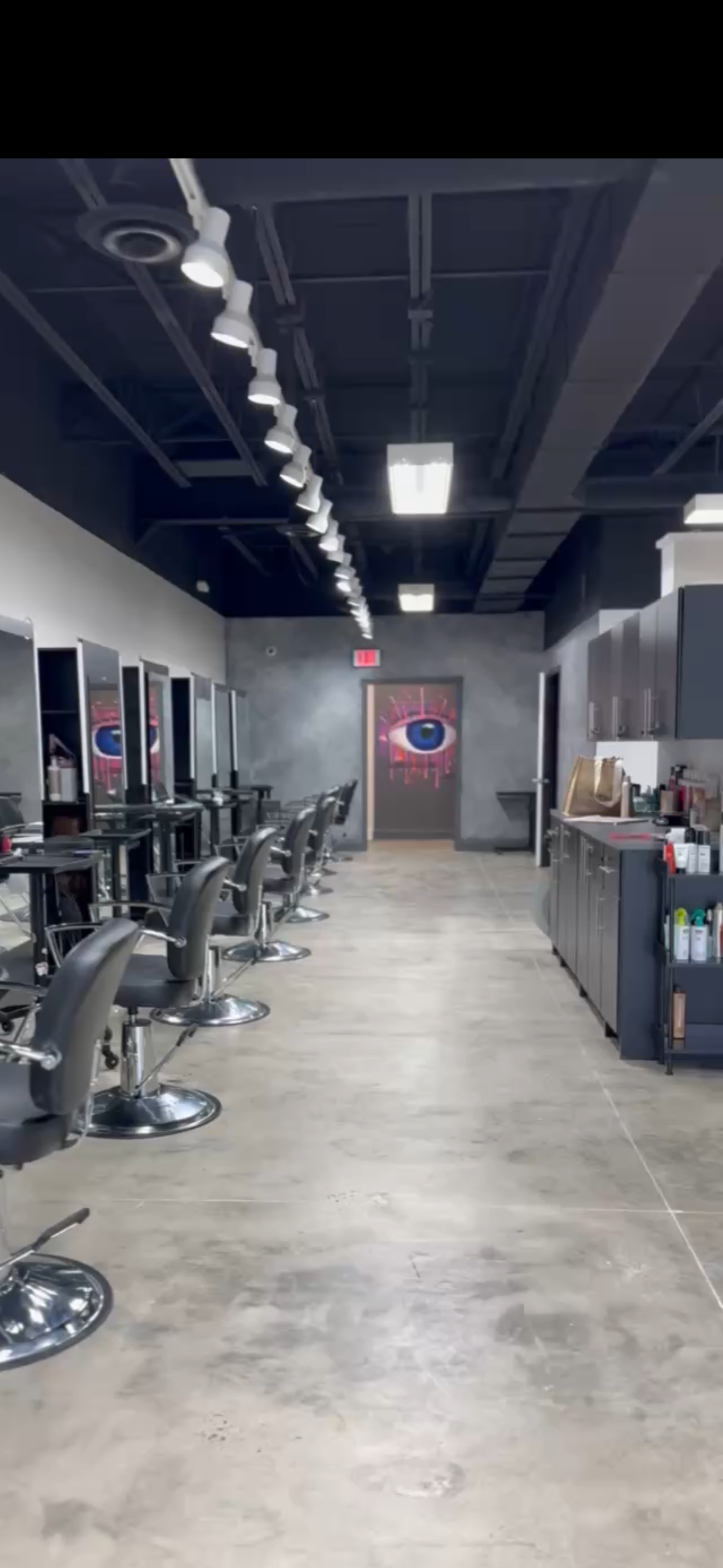 A modern industrial feel hair collective, hair salon in Rockville MD featuring sleep black styling charis and a custom artistic mural