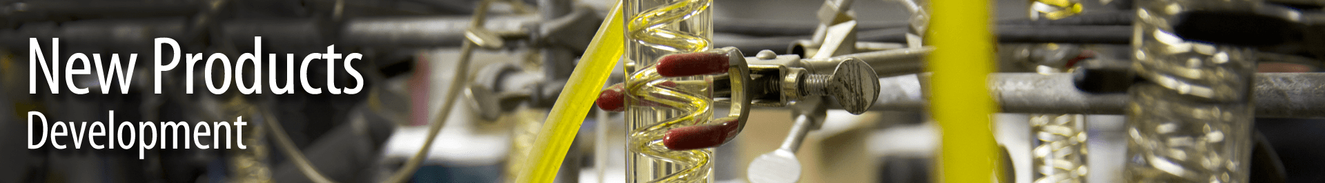 Close-up of laboratory equipment including glassware, metal clamps, and yellow tubing in a scientific research setting.