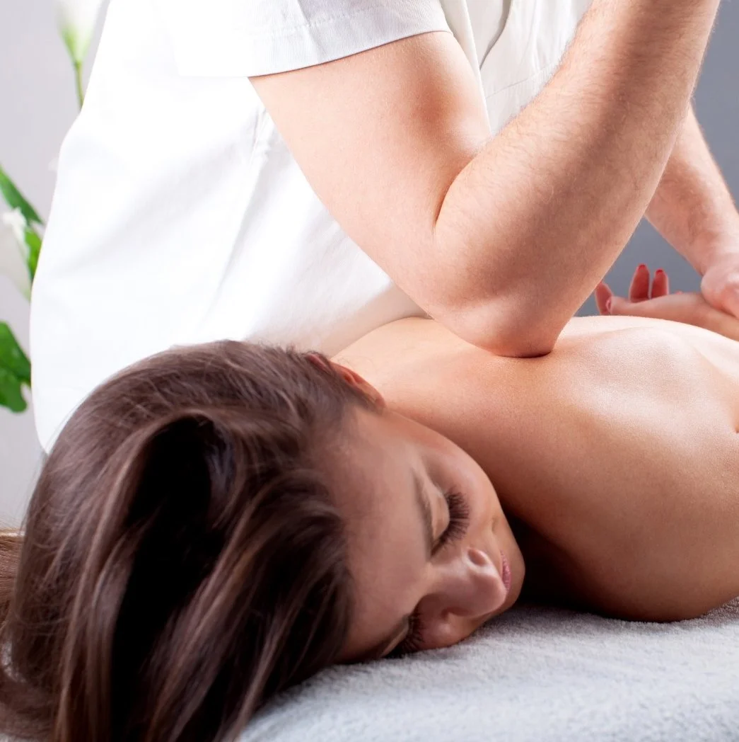A woman receiving a massage from a therapist in a spa or massage clinic.