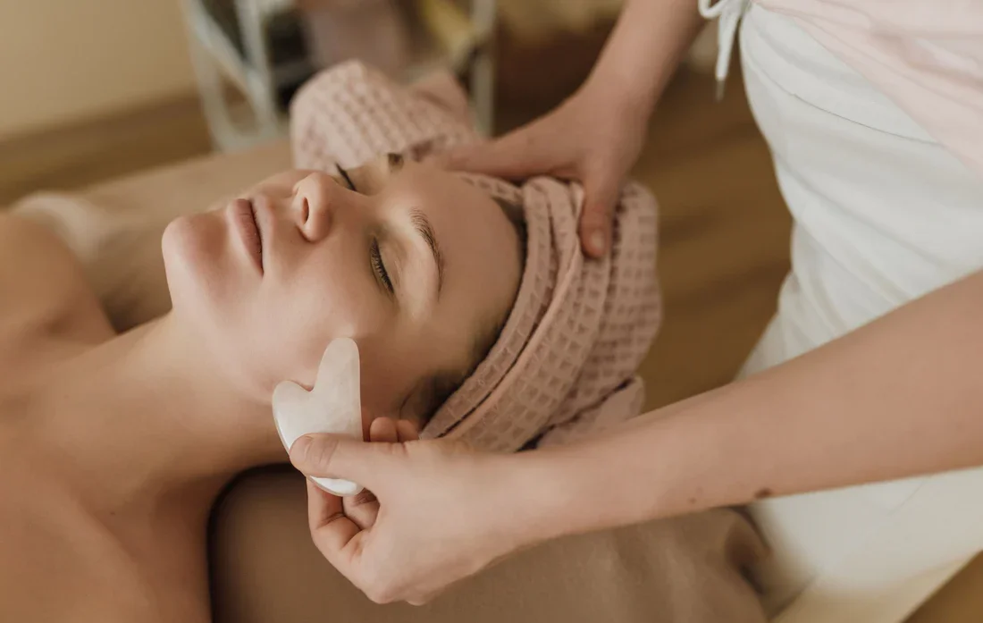 Person receiving a facial treatment with emotional support from a therapist in a spa or clinic setting.