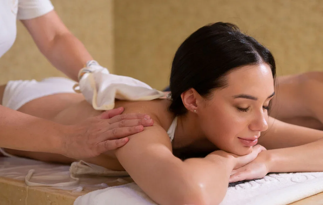 A woman receiving a back massage in a spa setting