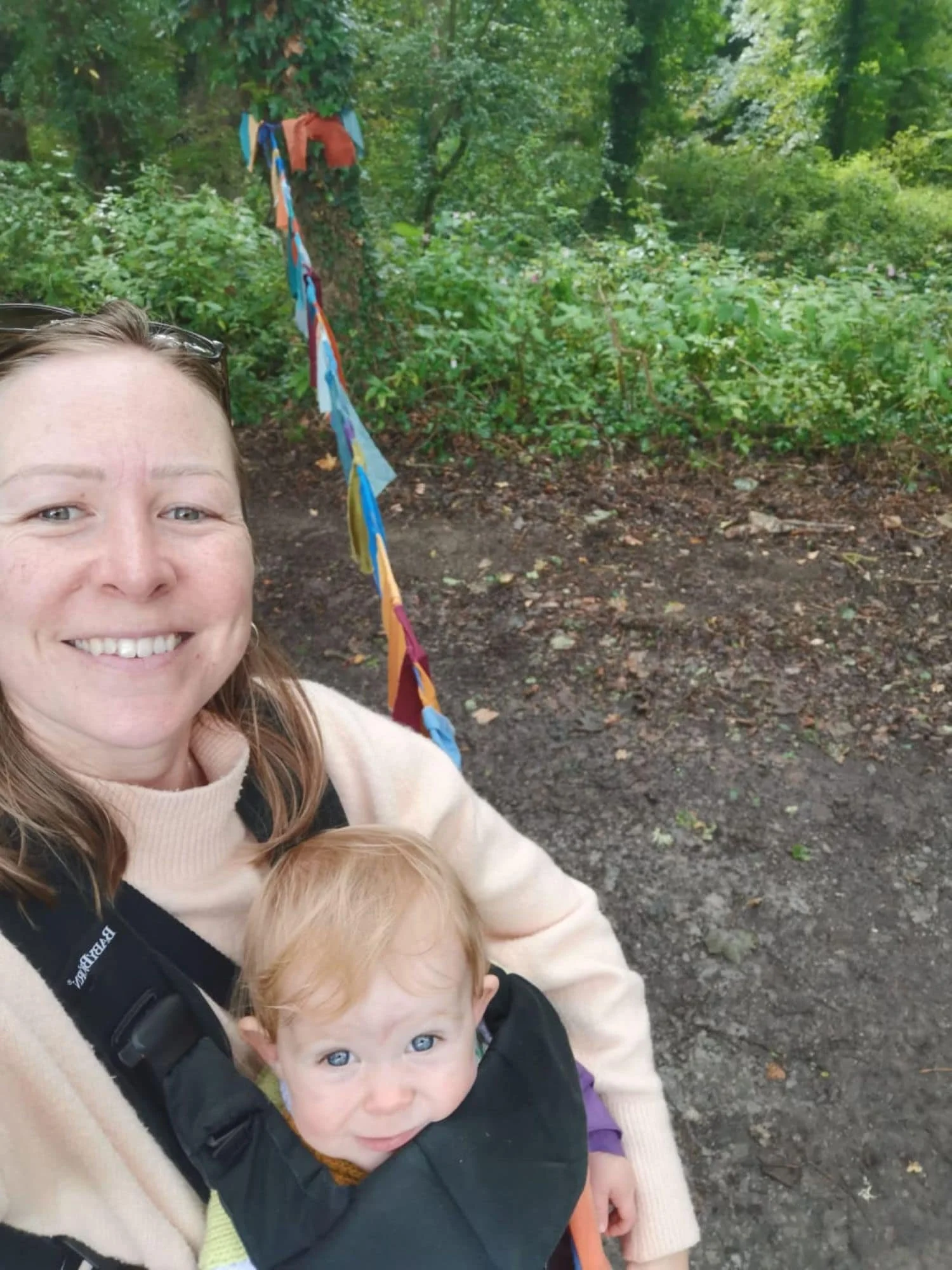 A mother wearing her baby in a carrier