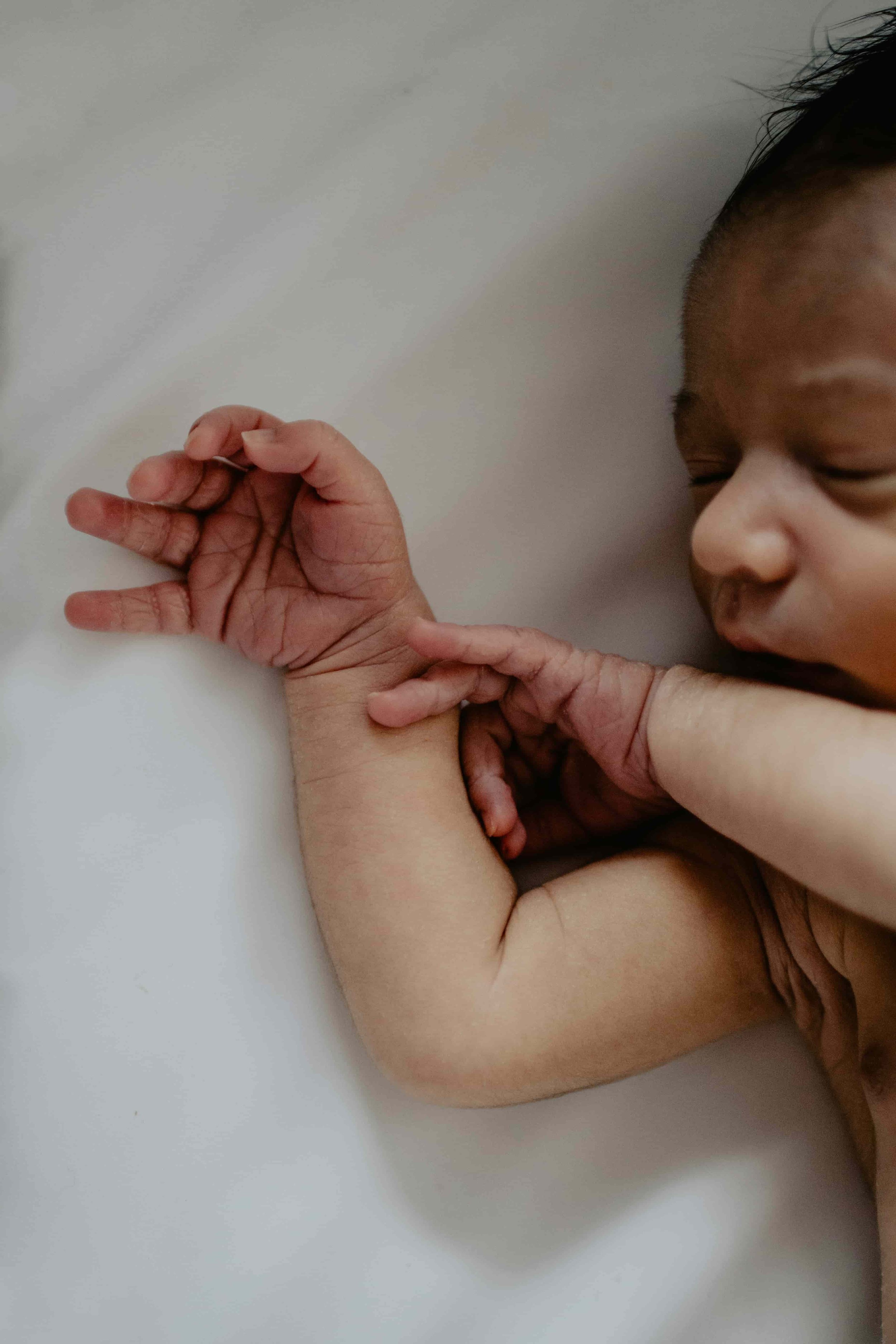 A photo of a newborn baby's face and hands