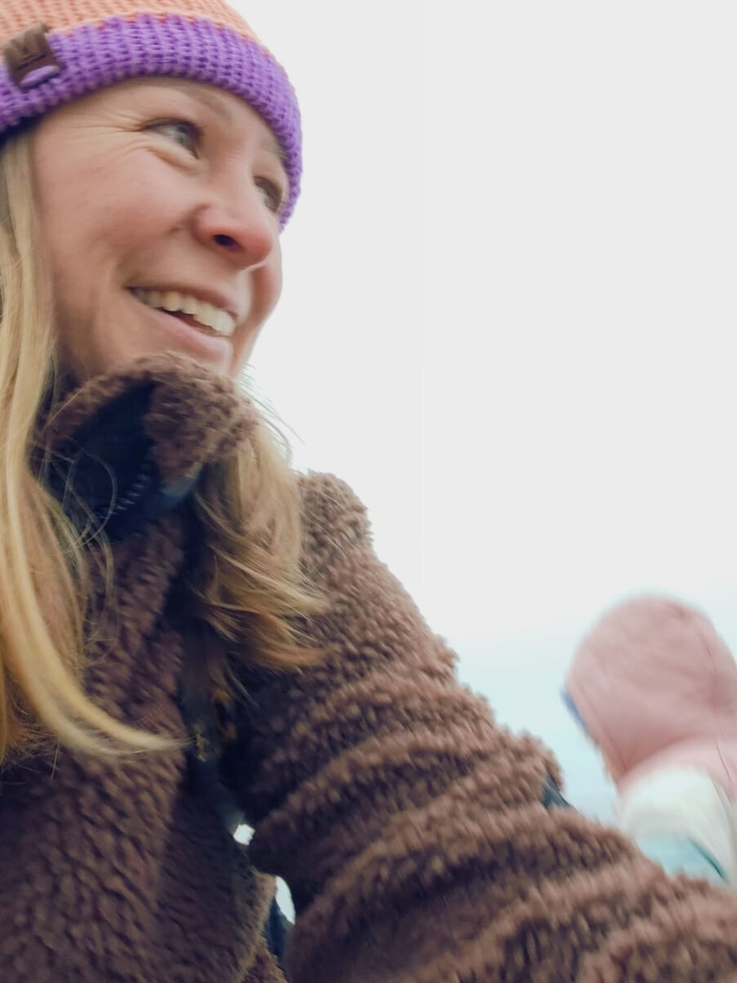 Alex the doula wearing a hat with her daughter in the background