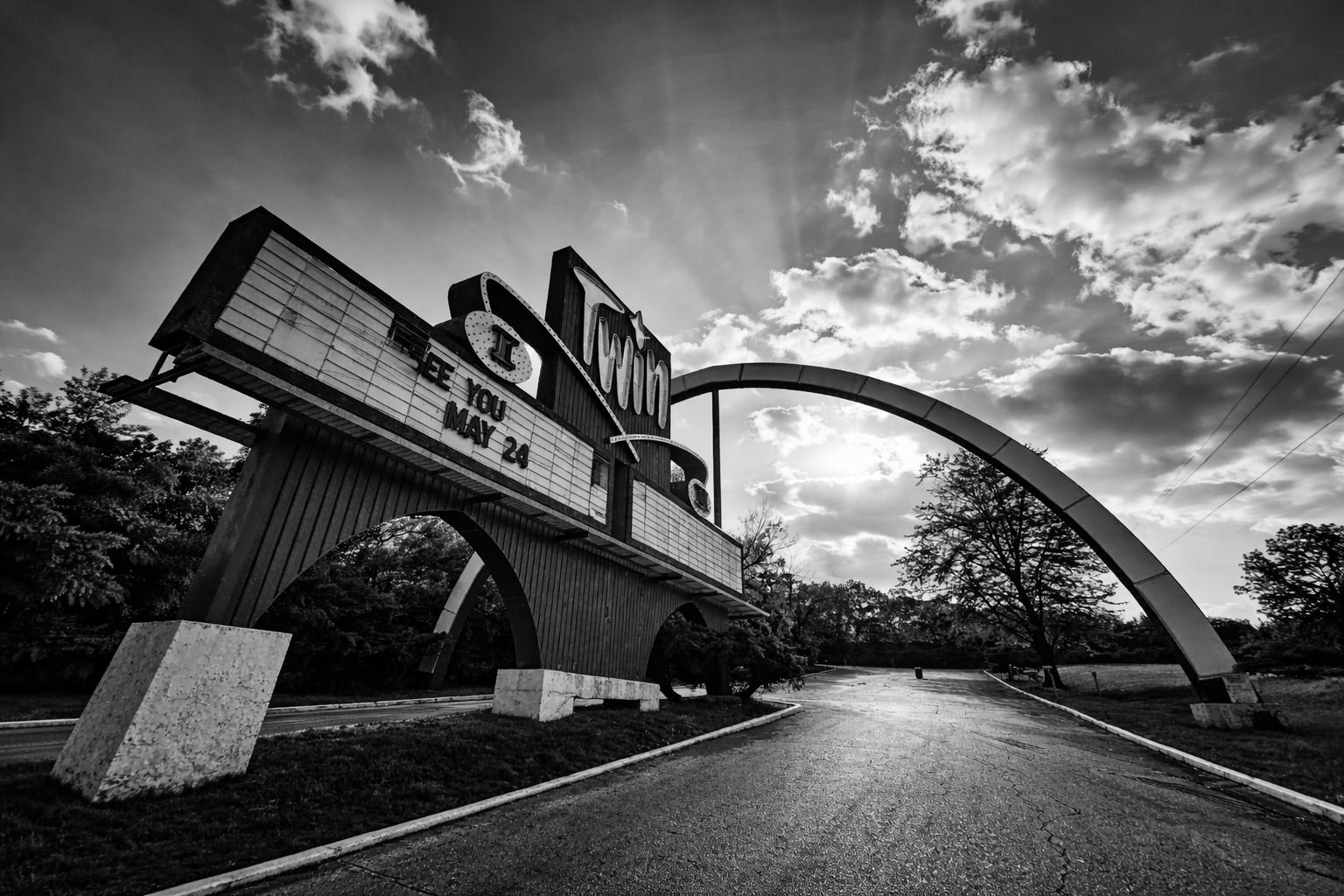 "Between Showings"
The arch still stands, but the stories have moved on. Beneath it, the empty road waits—no longer arrival, not yet memory.