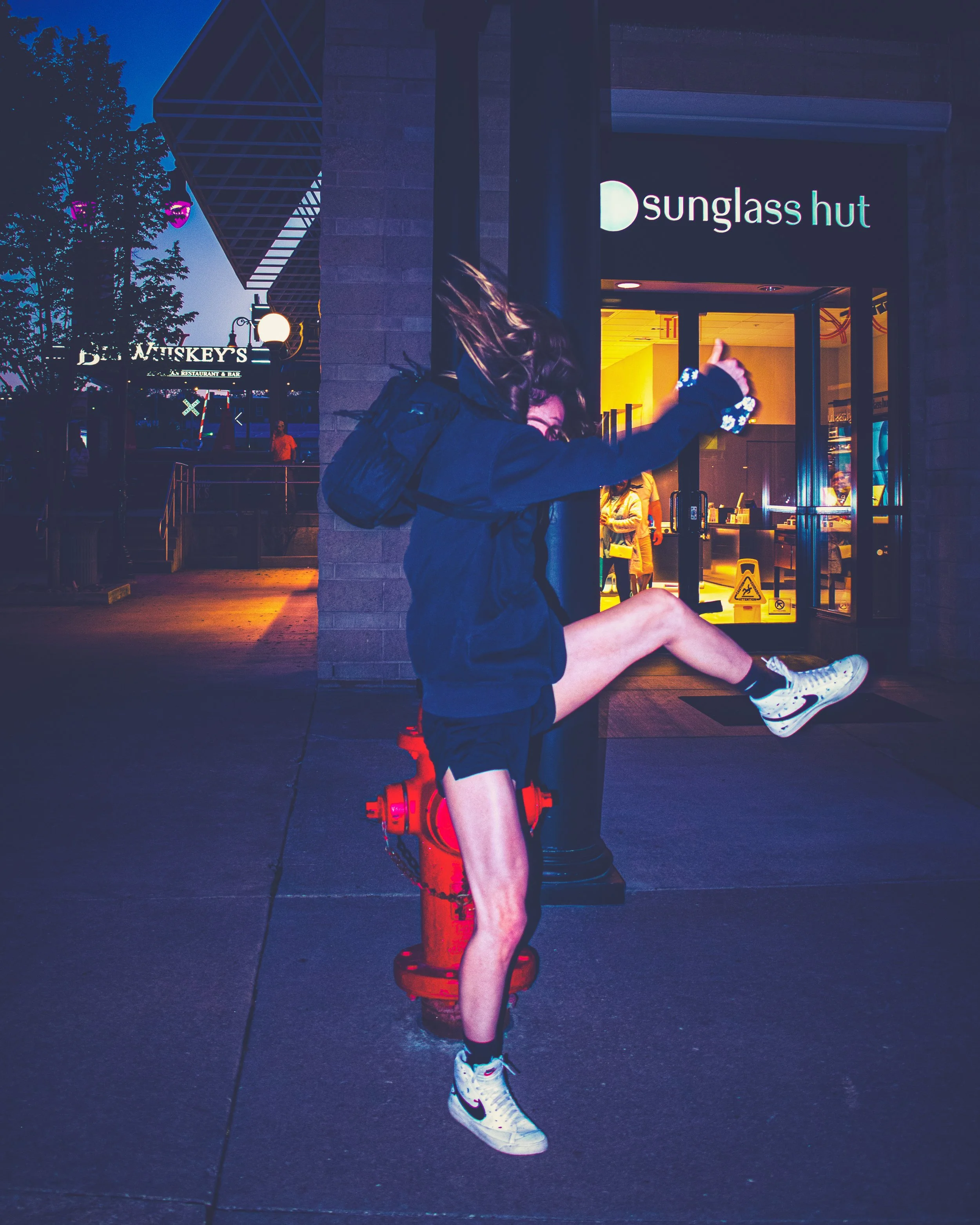 "Clearing the Moment"
She lifts mid-stride over the hydrant, caught between ground and landing. The motion is instinctive—no pause, just momentum.