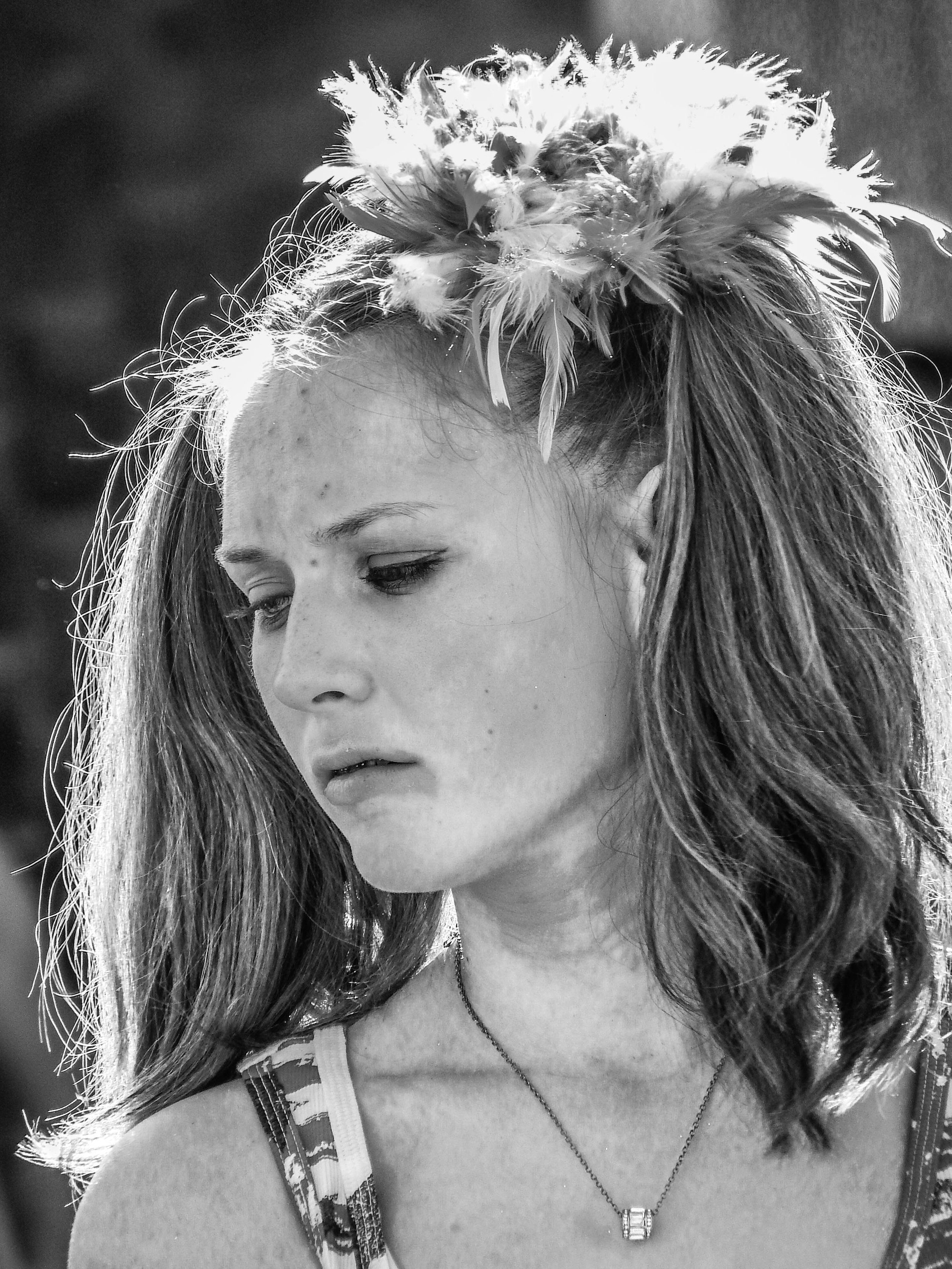 "Elsewhere"
Surrounded by celebration, she carries something far heavier. The moment passes around her—but not through her.