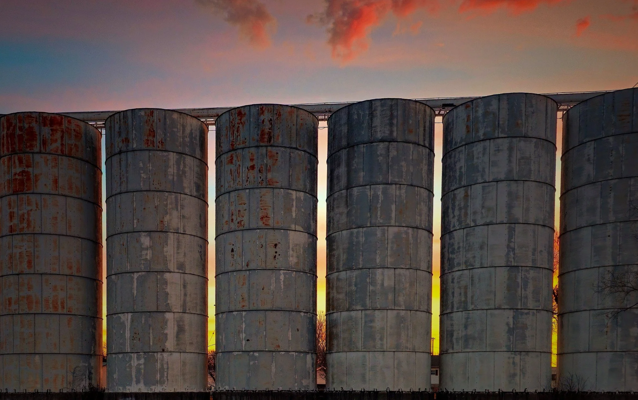 "After the Harvest"
Silos stand in quiet succession, holding what once sustained. Their purpose lingers, even as the fields fall silent around them.