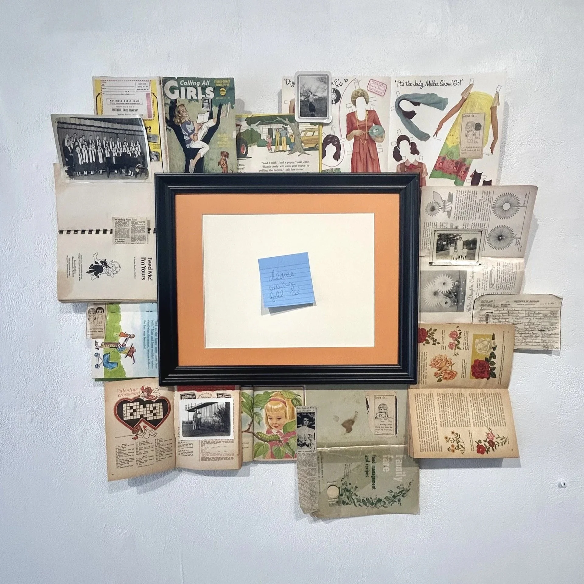 "MRS. Degree", 2026. Books, photographs, frame, sticky note, 35in x 40.5 in