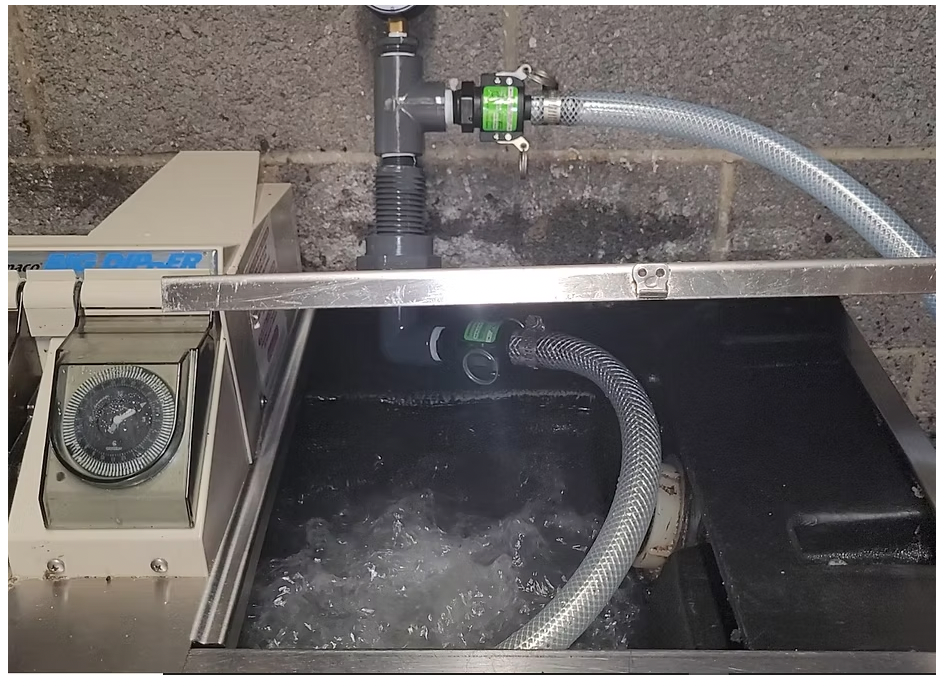 A commercial grease trap with a large amount clean, clear water bubbling.