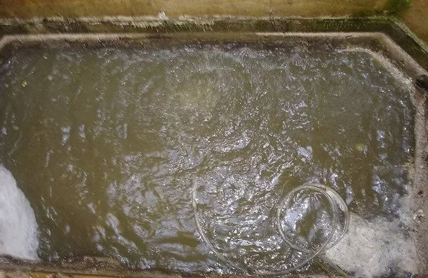 A top-down view of lift station wet well, with bubbling water and no buildup.