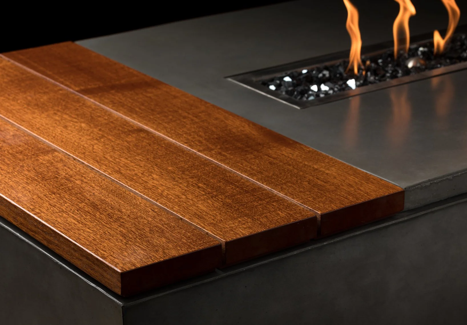 Close-up of a modern indoor fireplace with visible flames and a wooden frame around the hearth.