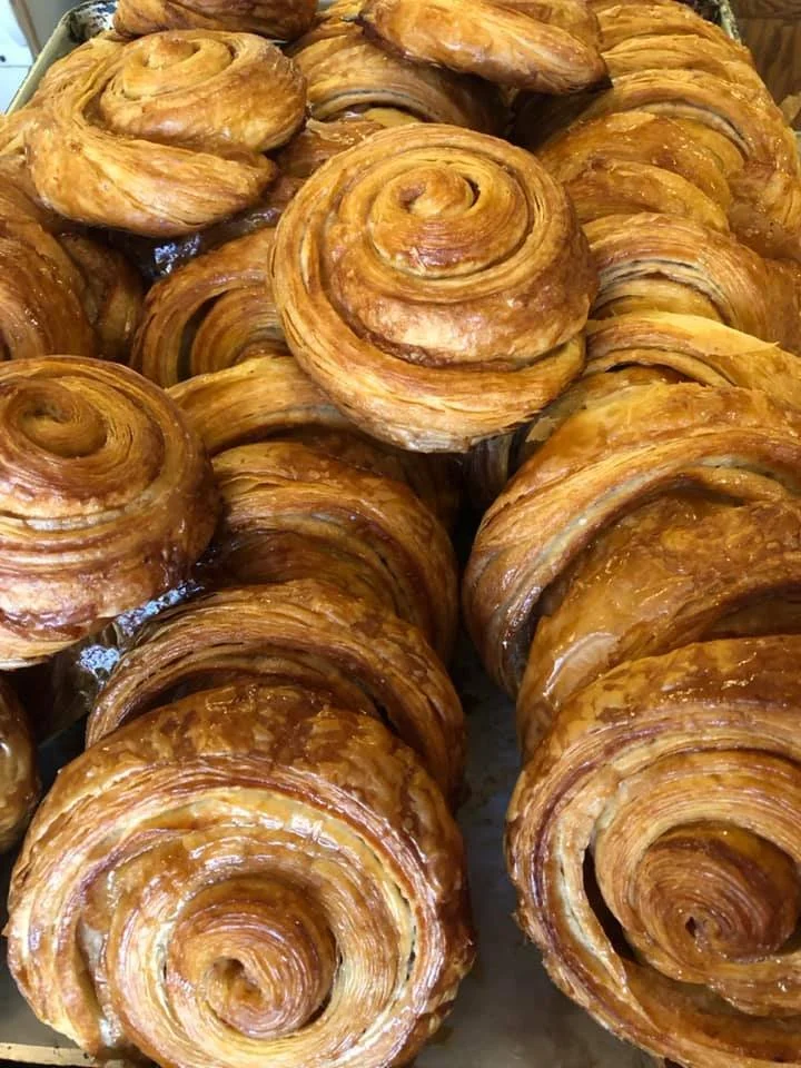 Group of freshly baked croissants with golden, flaky, spiral layers.