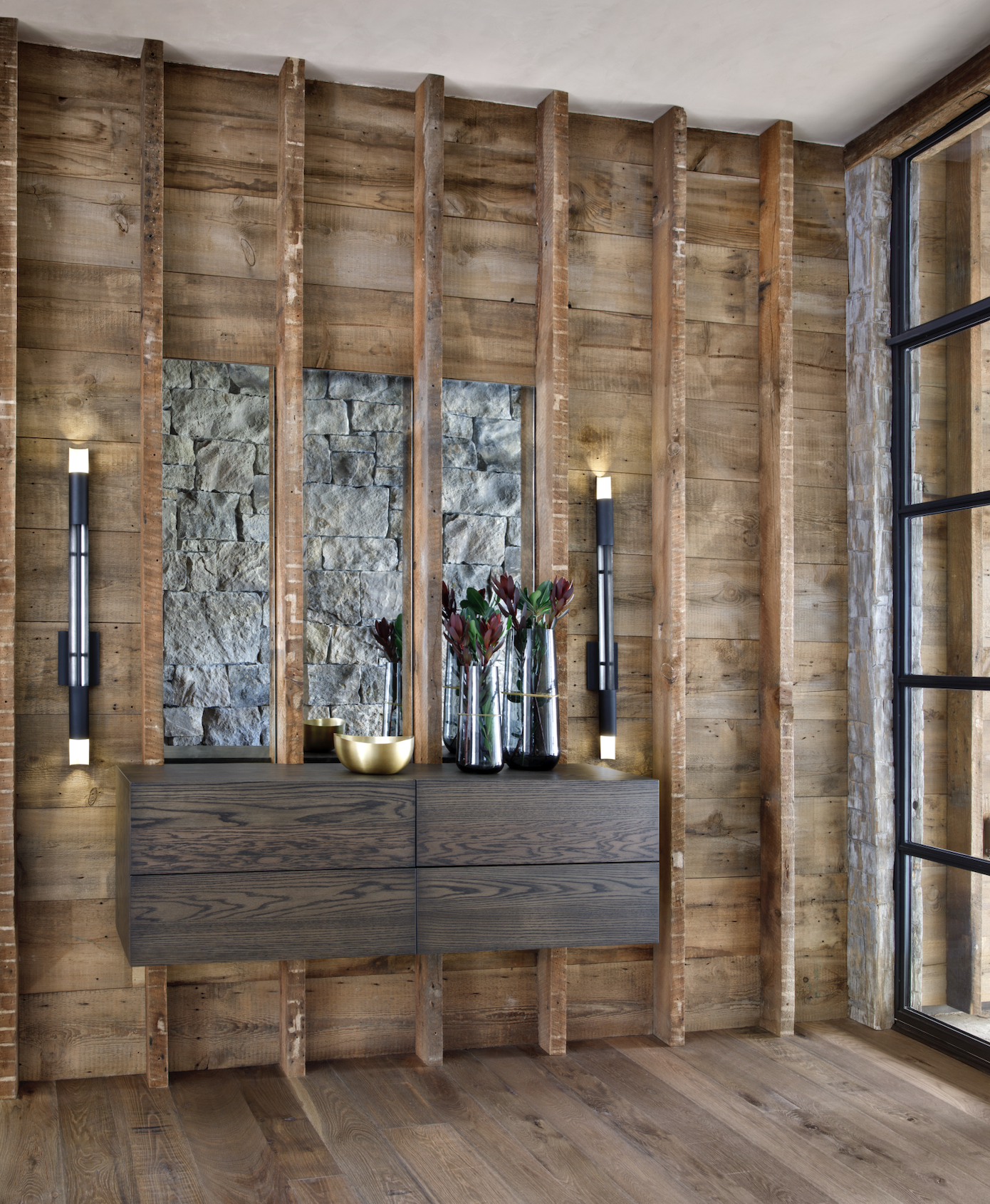 Floating console against reclaimed timber wall with stone detailing and large windows.