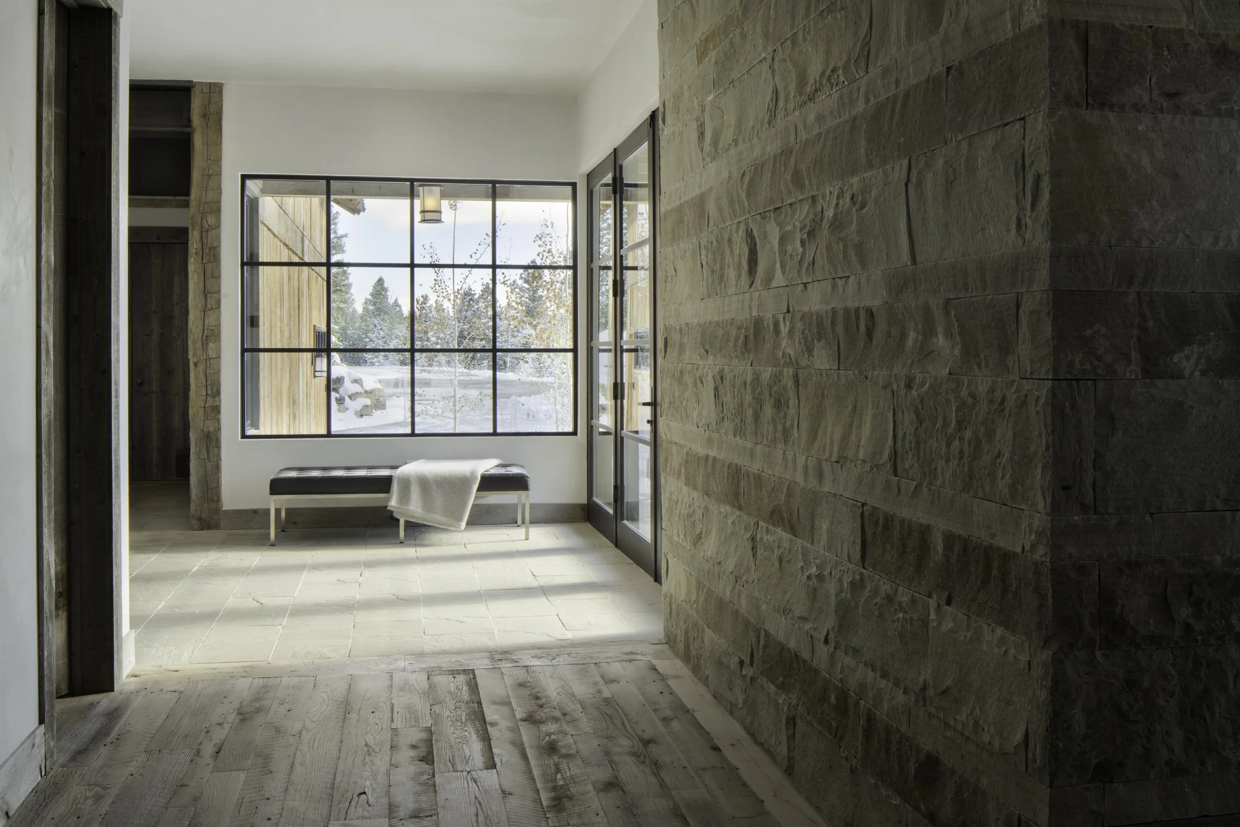 Entry hall with stone wall and built-in bench in Big Sky Montana